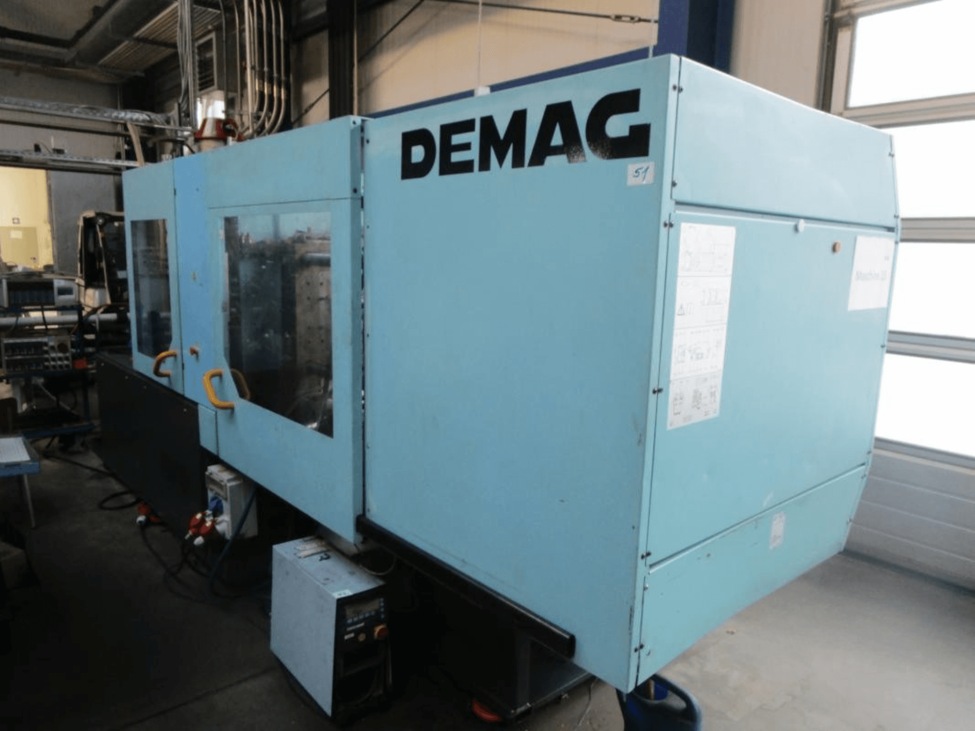 Vista frontale di una pressa a iniezione idraulica DEMAG Ergotech 150-610 Viva, con pannello di controllo e maniglie ben visibili.