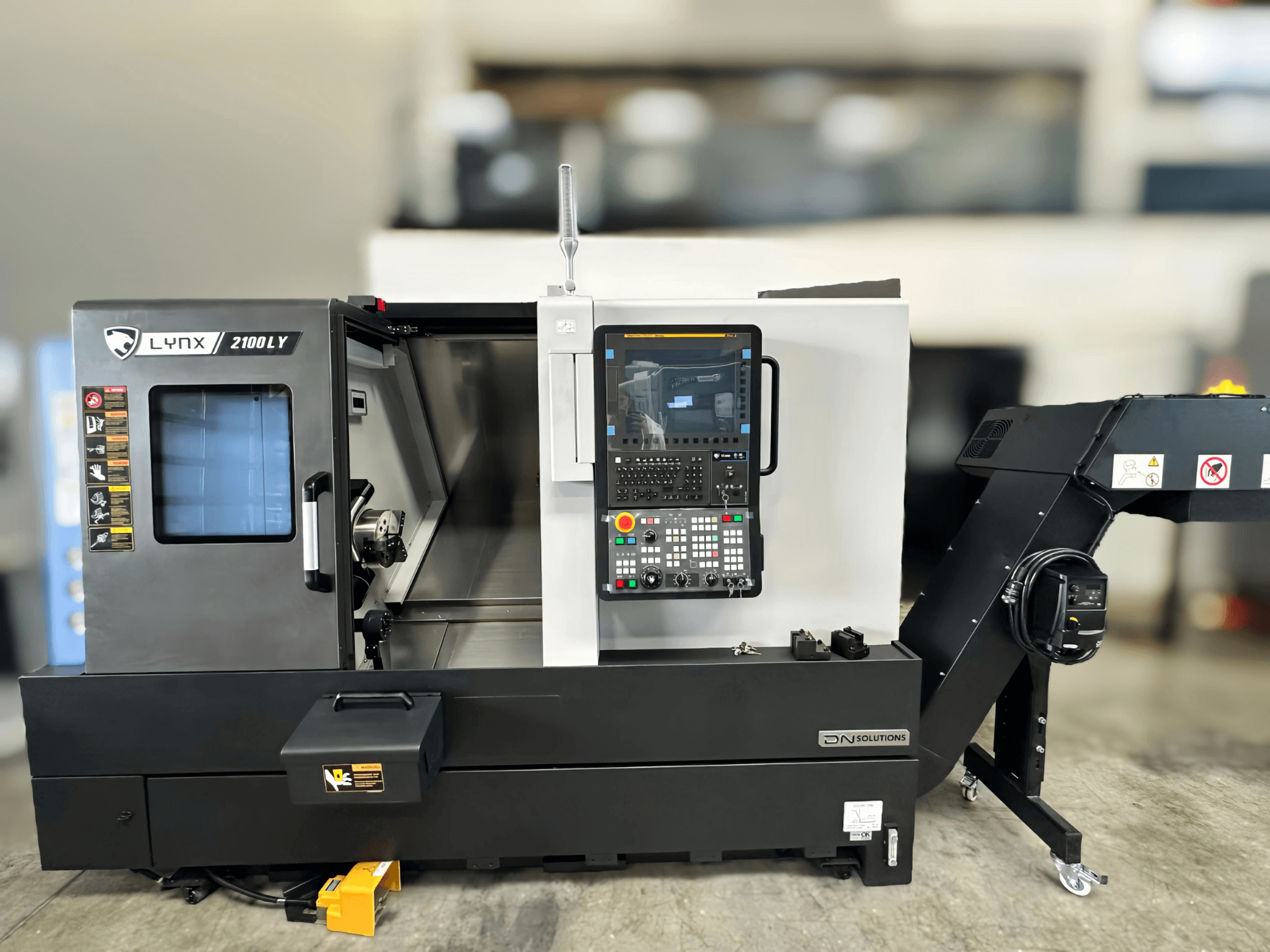 Tornio orizzontale DN SOLUTIONS LYNX 2100LYB, vista frontale, con pannello di controllo e porta aperta che rivela l'interno.