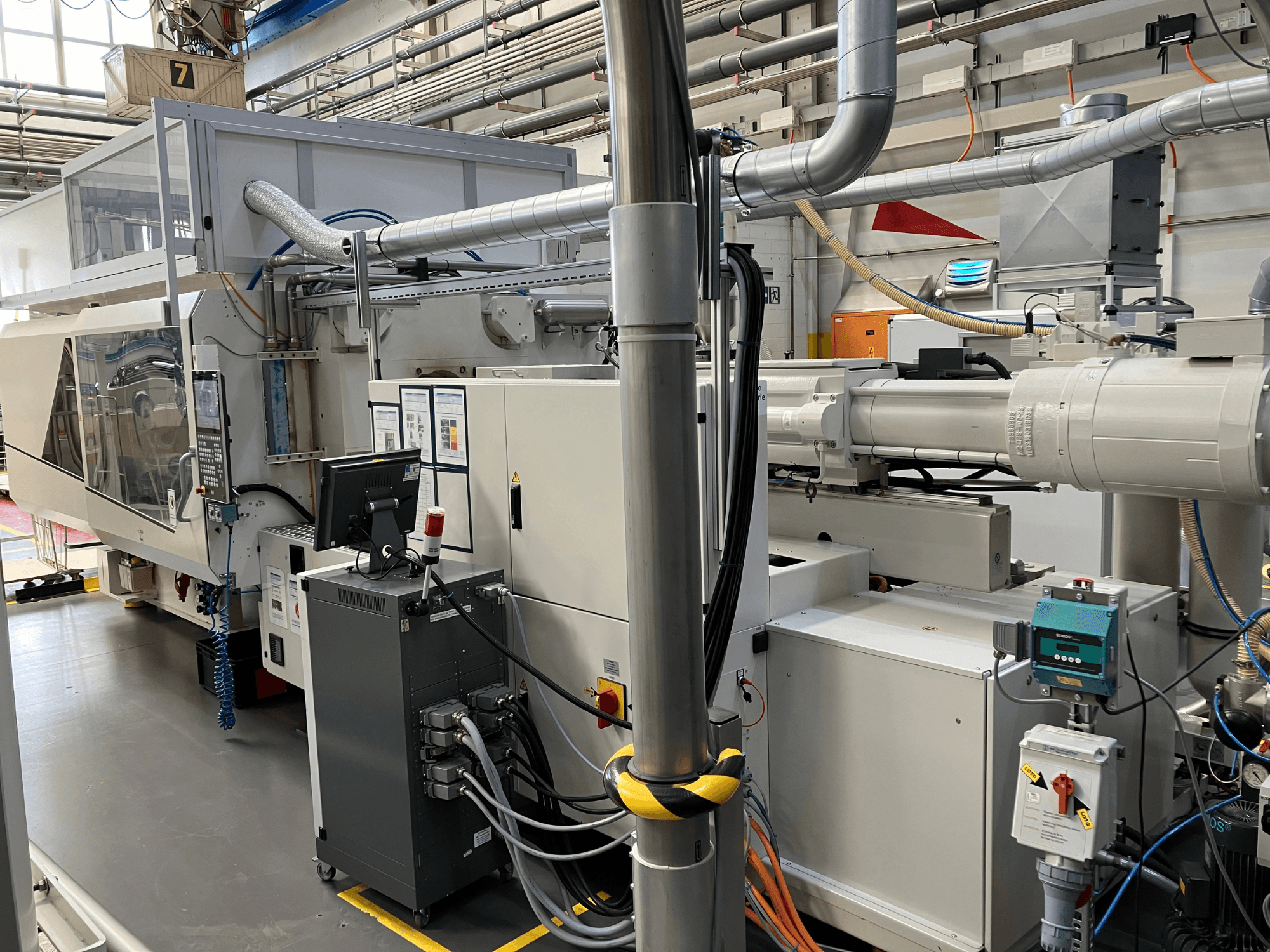 Macchinario industriale con pannello di controllo, vista frontale, con tubi, componenti elettrici e caratteristiche di sicurezza.