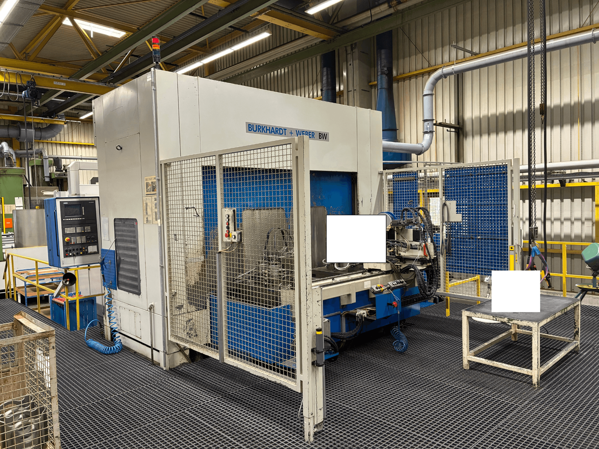 Centro di lavoro BW di Burkhardt + Weber, vista frontale, dotato di pannello di controllo e di copertura di sicurezza, situato in un ambiente industriale.