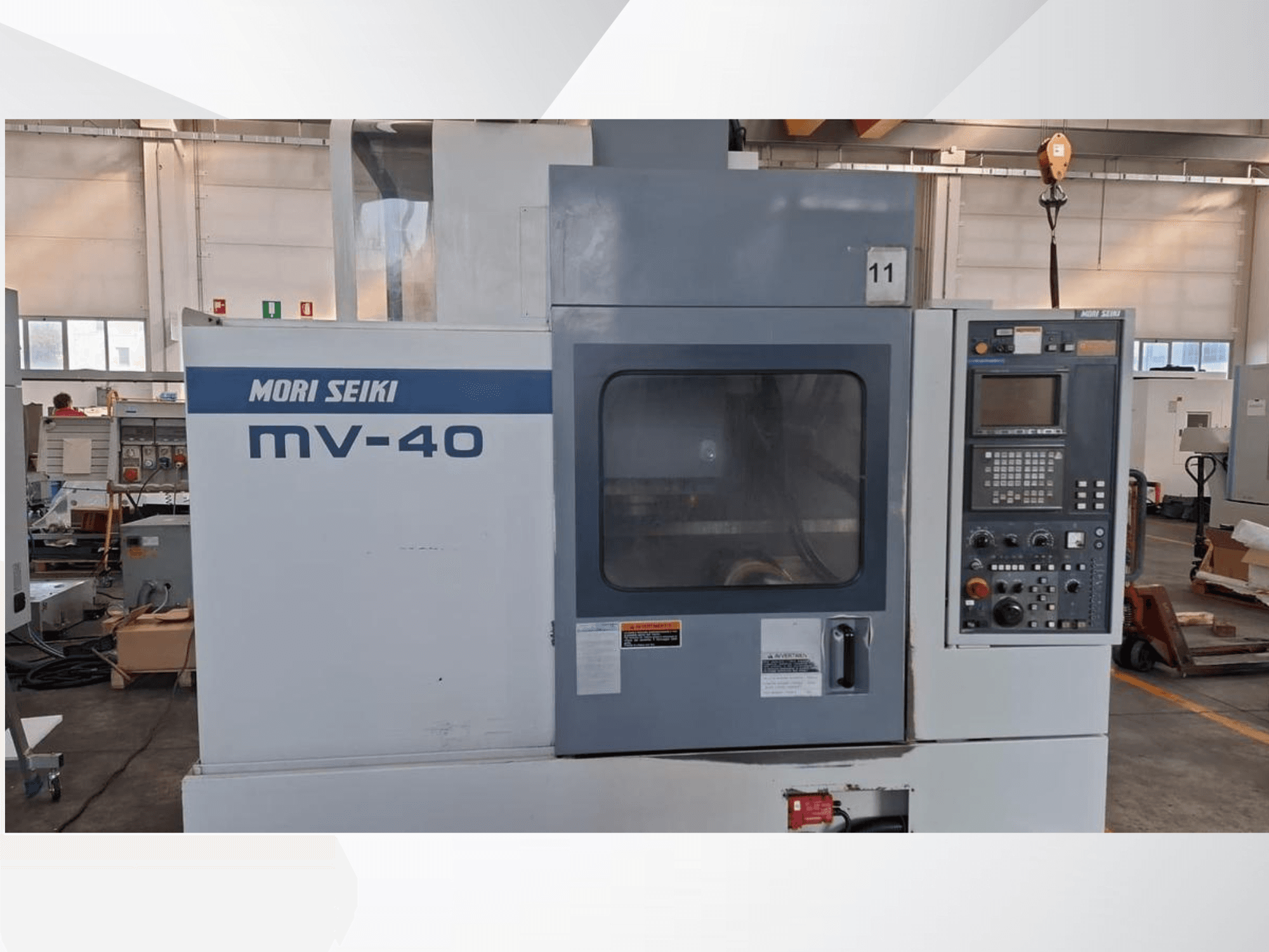 Centro di lavoro verticale MORI SEIKI MV-40, vista frontale con pannello di controllo e finestra, in un'officina.
