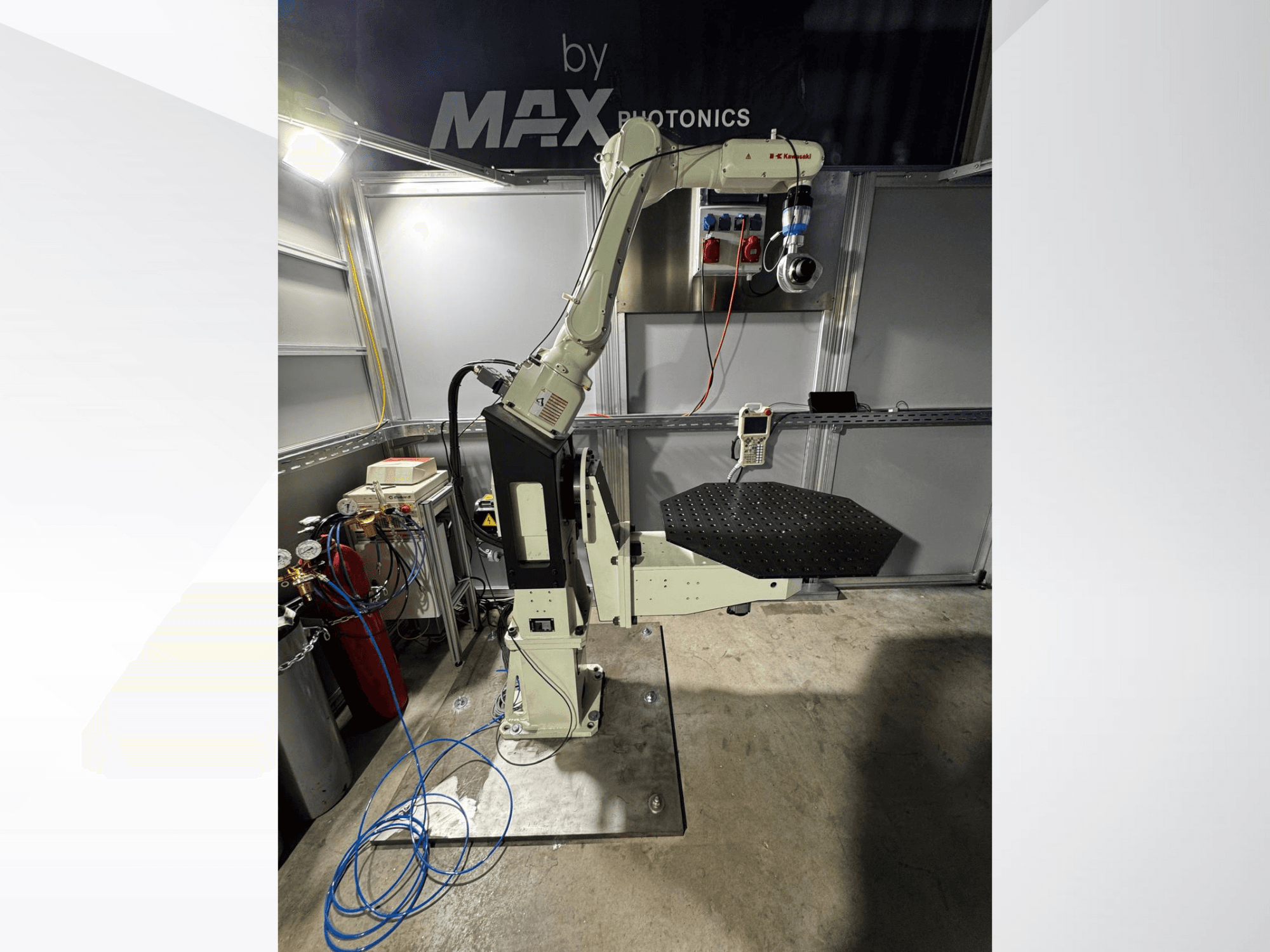 Apparecchio a braccio robotico Max Photonics, vista frontale, con piattaforma nera perforata e pannello di controllo con indicatori e cavi.