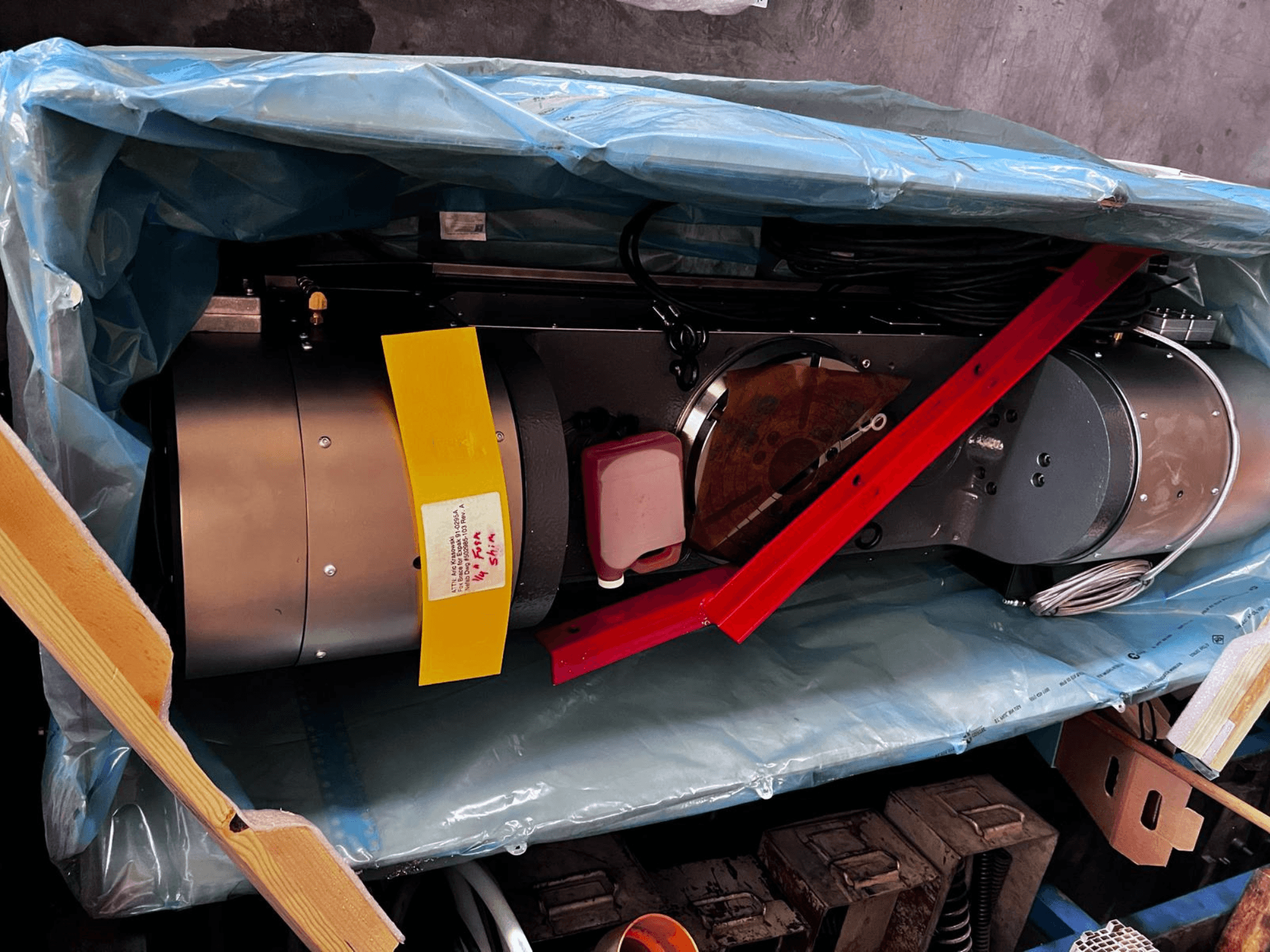 Il dispositivo motore, parzialmente visibile nella confezione, presenta un esterno argentato, indicatori colorati e una staffa di supporto rossa.