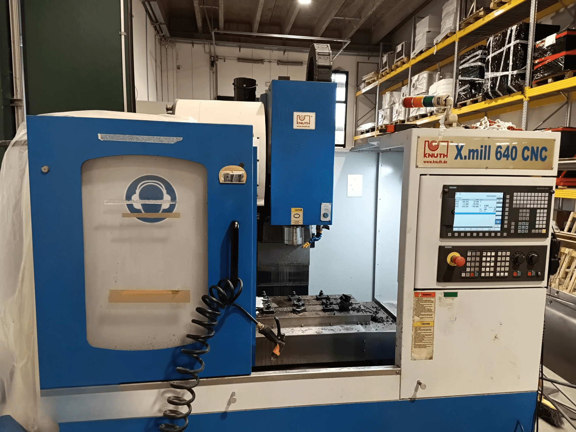 Macchina CNC Knuth X.mill 640 in vista laterale, con pannello di controllo, area del mandrino e impostazione del pezzo visibile.