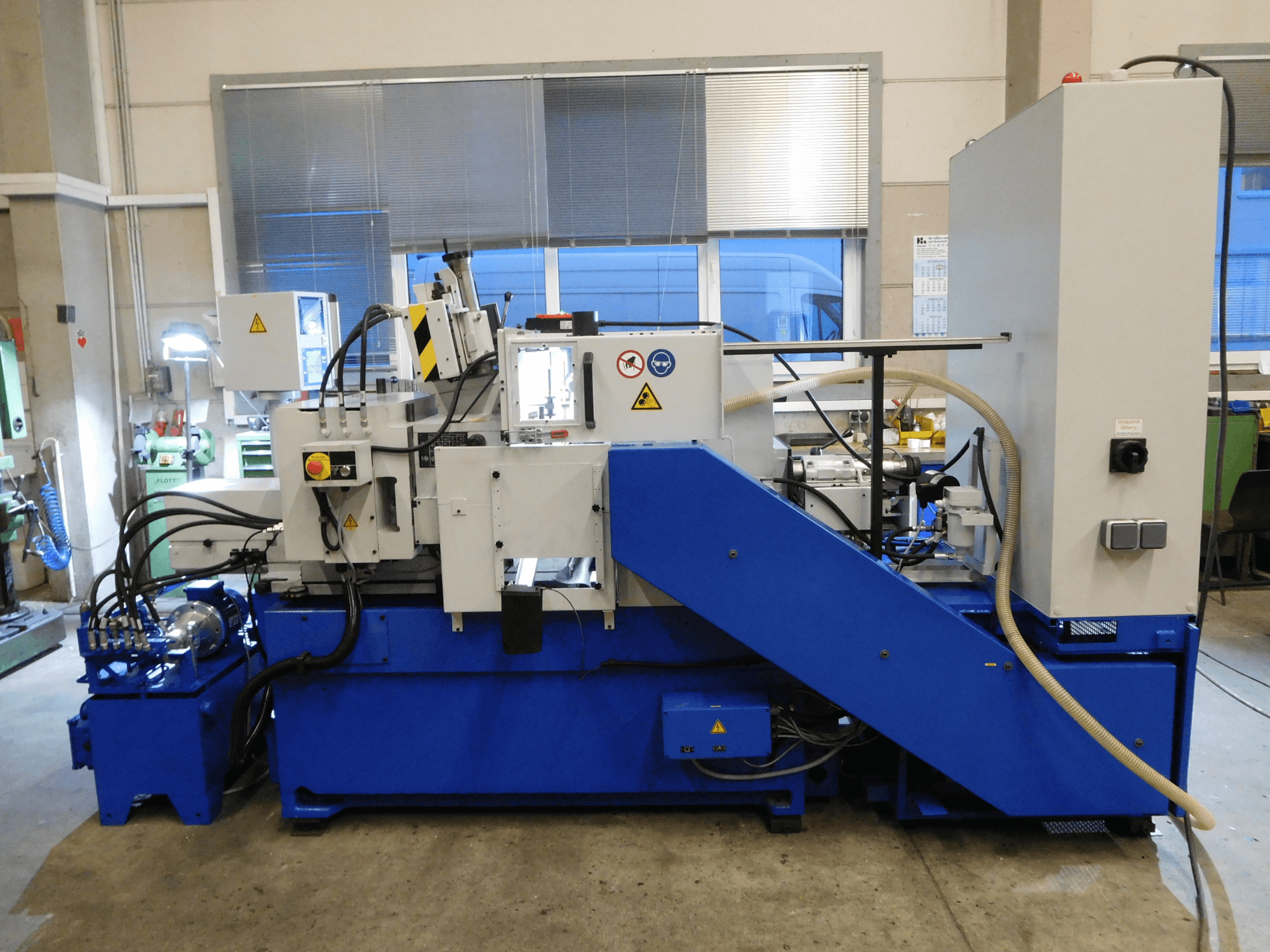 Rettificatrice senza centri Schaudt Mikrosa SASL 125, vista laterale, con base blu e pannello di controllo, che mostra le caratteristiche operative.