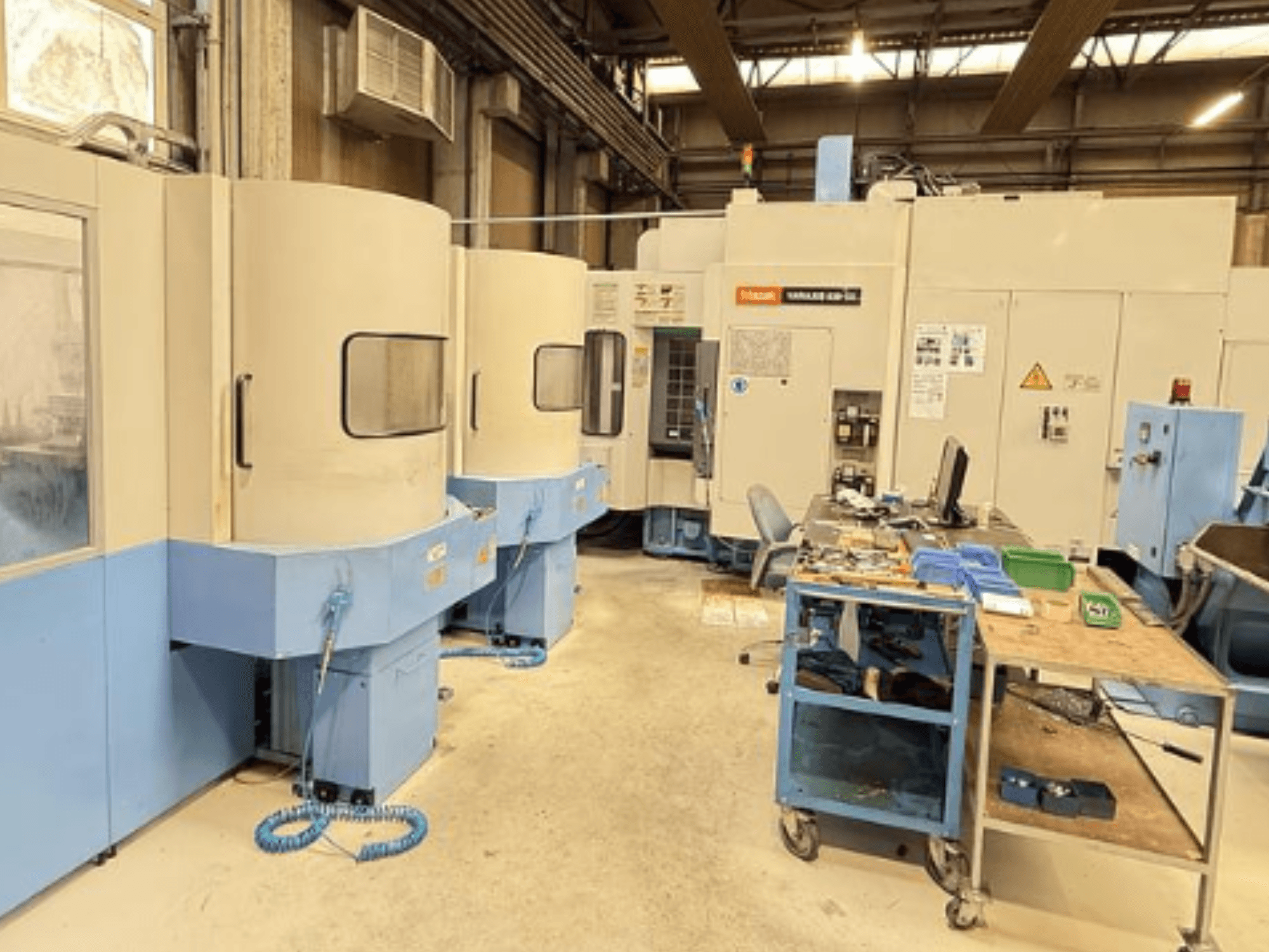 Centro di lavoro verticale Mazak Variaxis 630-5X in un'officina, vista frontale che mostra il pannello di controllo e l'area di stoccaggio degli utensili.