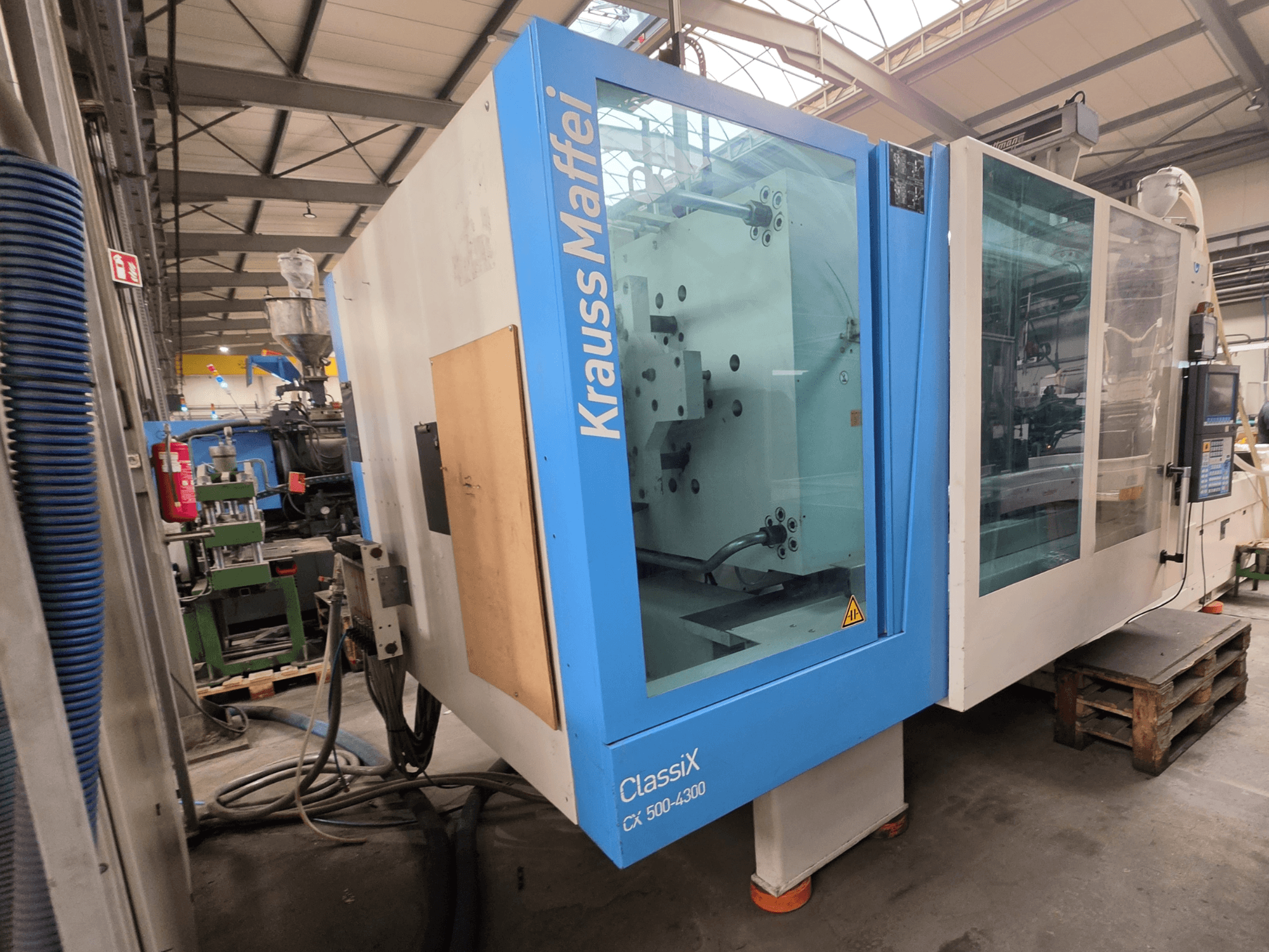 Pressa a iniezione idraulica Krauss Maffei 500-4300 CX, vista laterale, con pannello di controllo e componenti operativi.