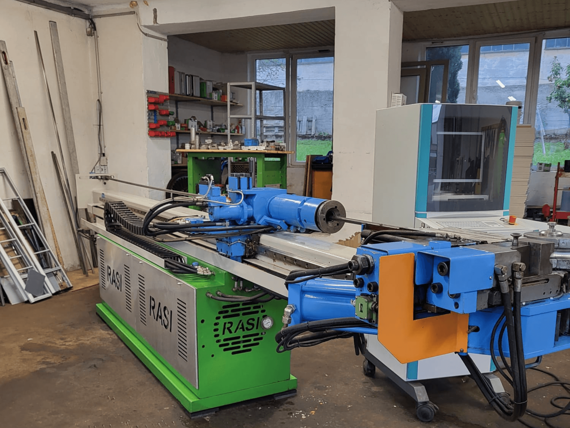 Macchina utensile Rasi S 80.6 L G-V3C50 in un'officina, vista laterale che mostra i componenti blu e verdi e il pannello di controllo.