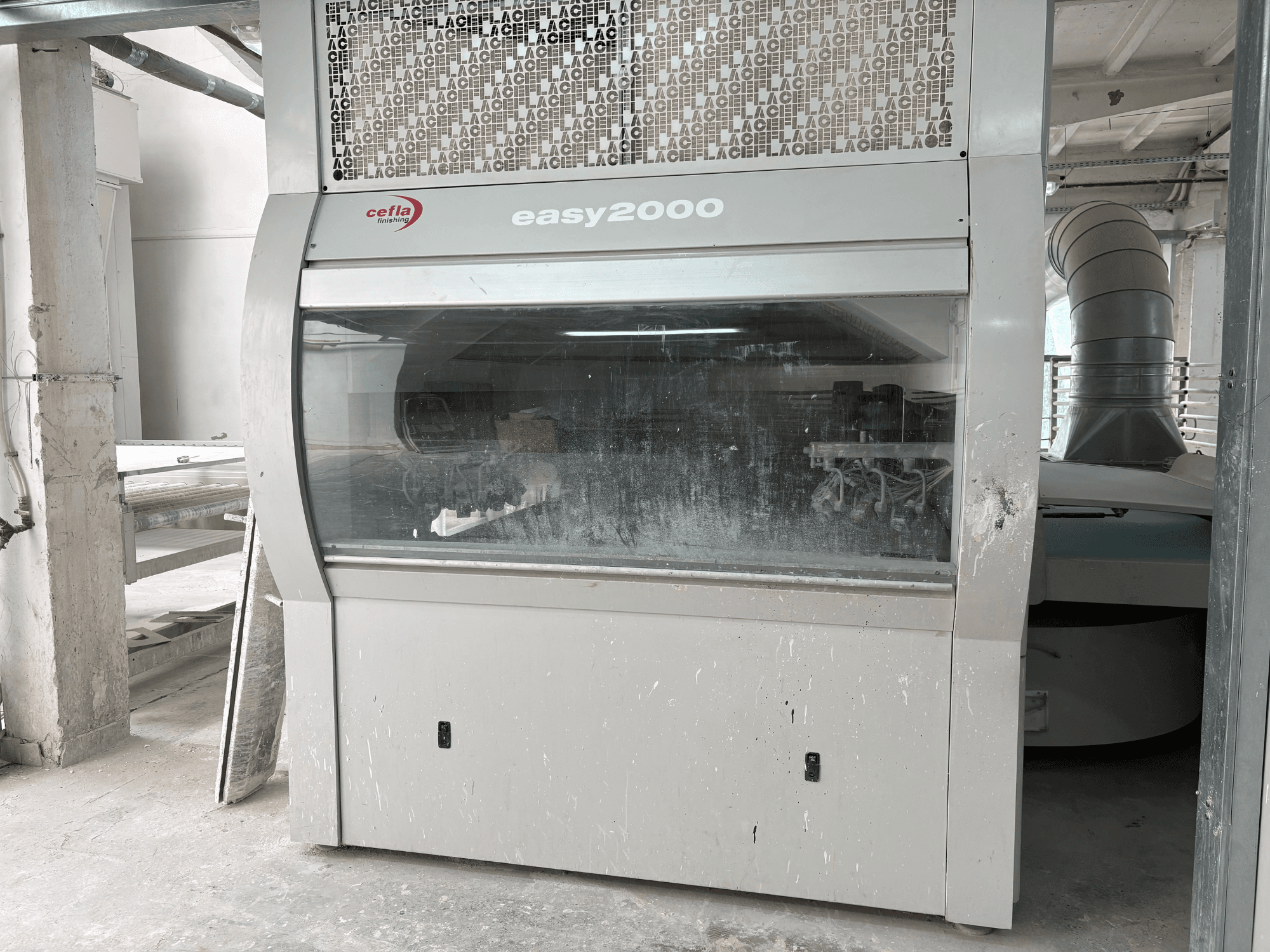 Macchina Cefla EASY 2000 D vista frontale, caratterizzata da un ampio pannello trasparente, una superficie impolverata e componenti interni visibili.