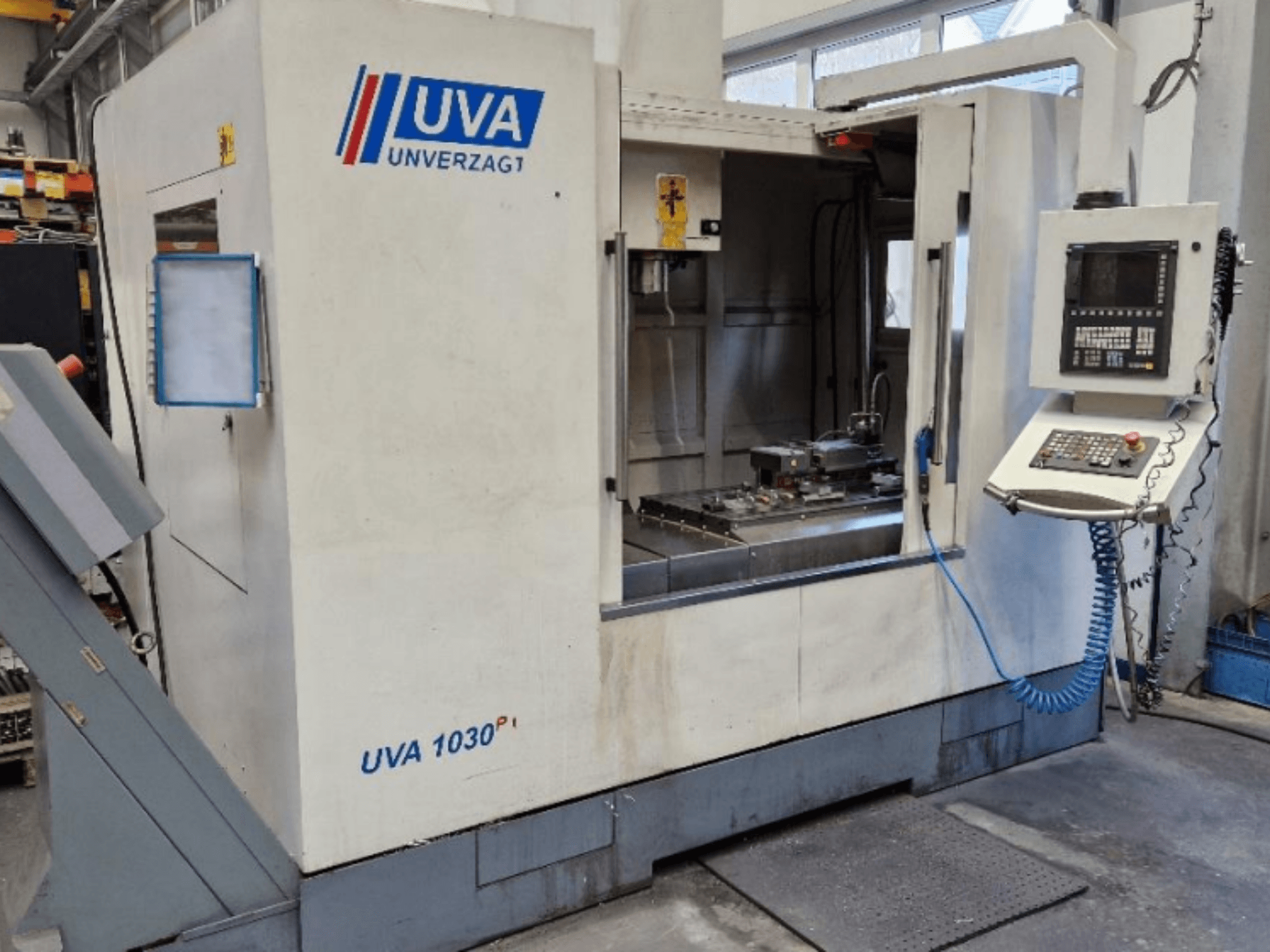 Macchina utensile UVA 1030P in un'officina, vista frontale che mostra il pannello di controllo, l'area di lavoro e la superficie di taglio pulita.