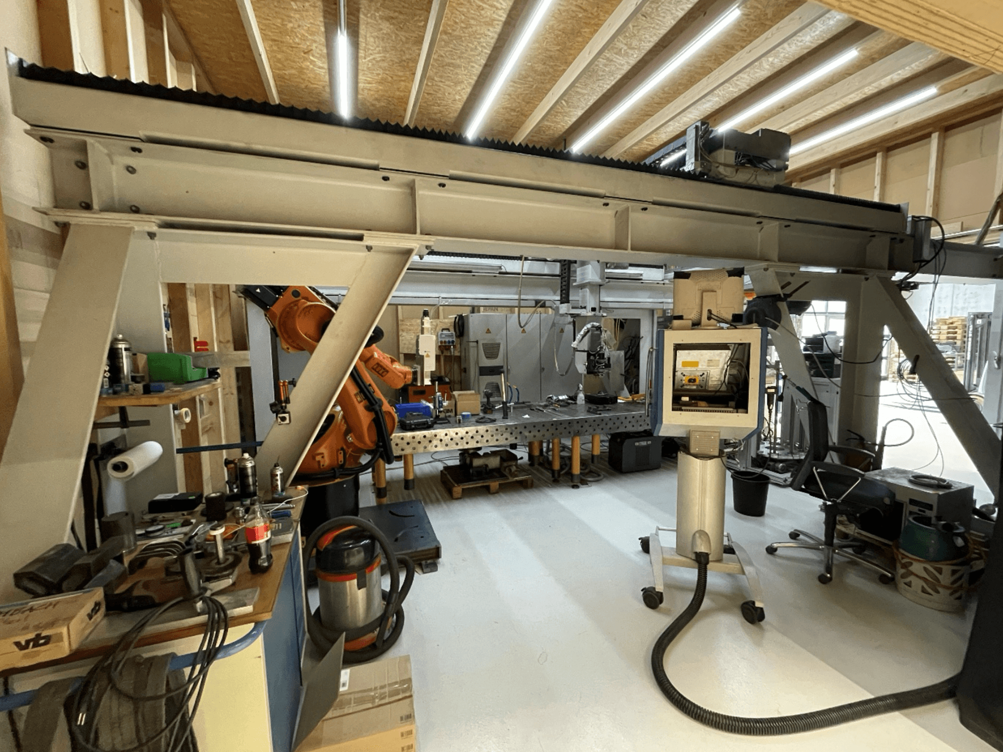 Macchina utensile Stiefelmayer Laserhärtenanlage, vista frontale, con braccio robotico e pannello di controllo in un'officina.