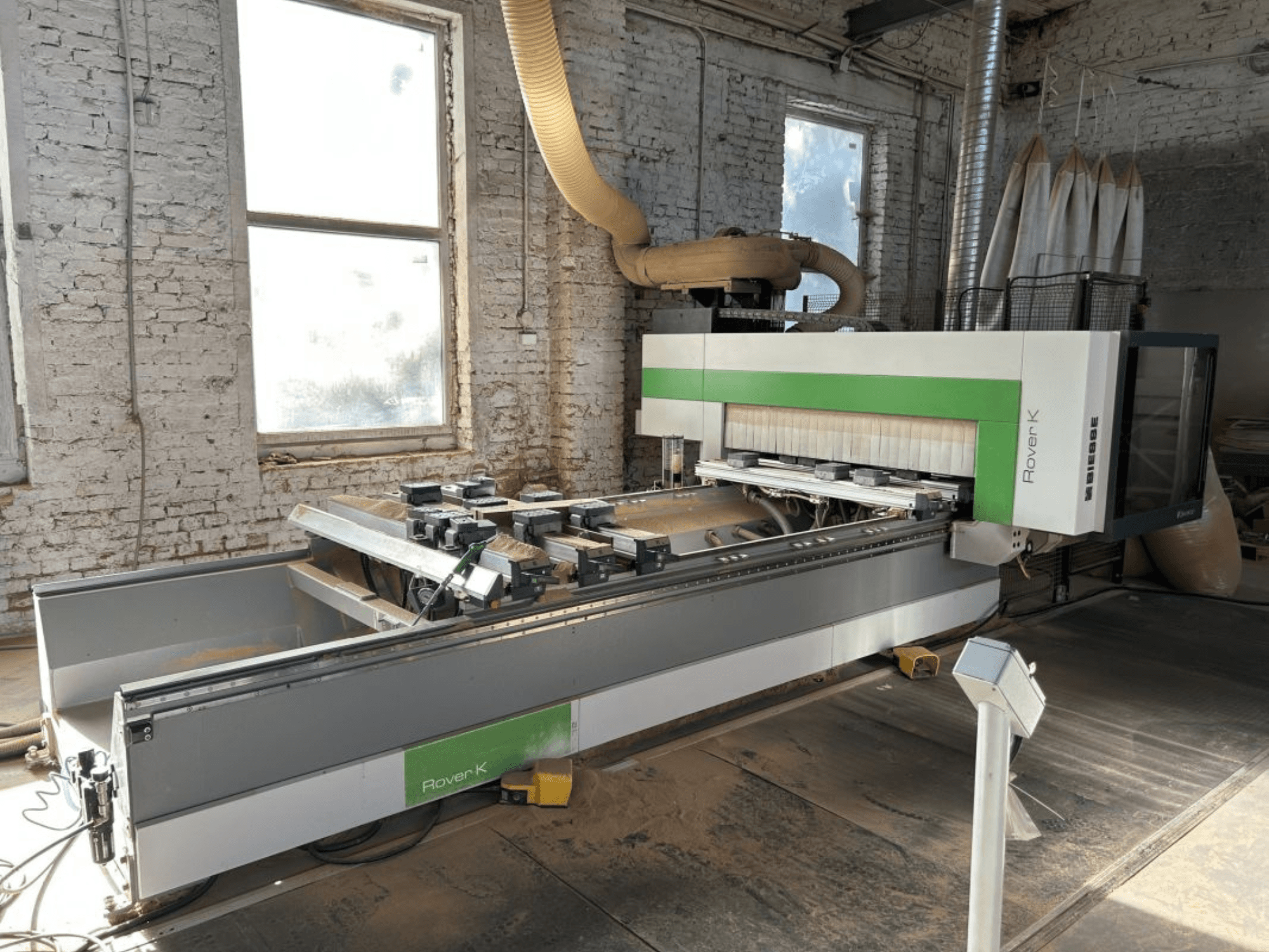 Centro di lavorazione CNC BIESSE Rover K 1532 G in un'officina, visto di fronte, con in primo piano gli utensili da taglio e il piano di lavoro.