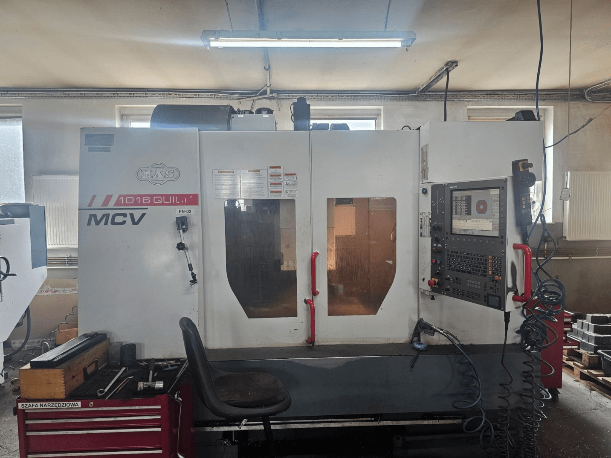 Macchina CNC MVS MCV 1016 QUILL, vista frontale, con pannello di controllo, cassetto portautensili e area di lavoro con utensili.