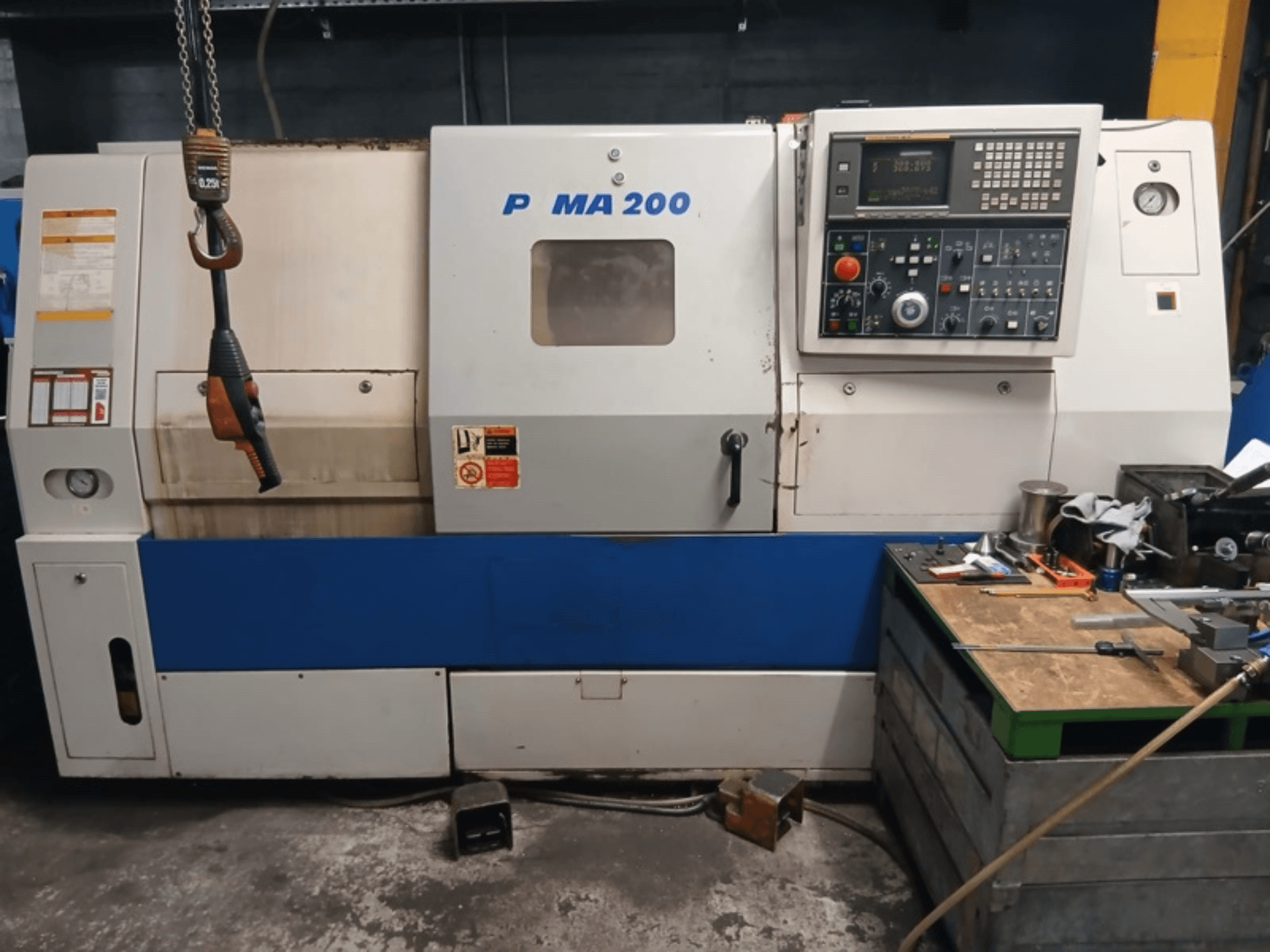 Vista frontale del tornio orizzontale DAEWOO EcoTurn 200, con pannello di controllo ed etichette di sicurezza.