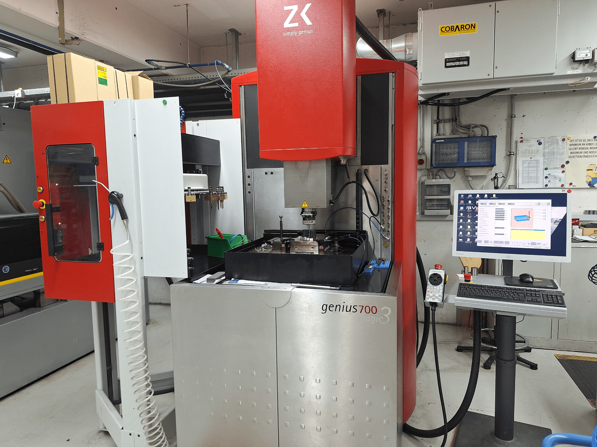 Fresatrice Genius 700 di ZK, vista frontale, con pannello di controllo touchscreen e area di lavorazione con utensili e materiali.