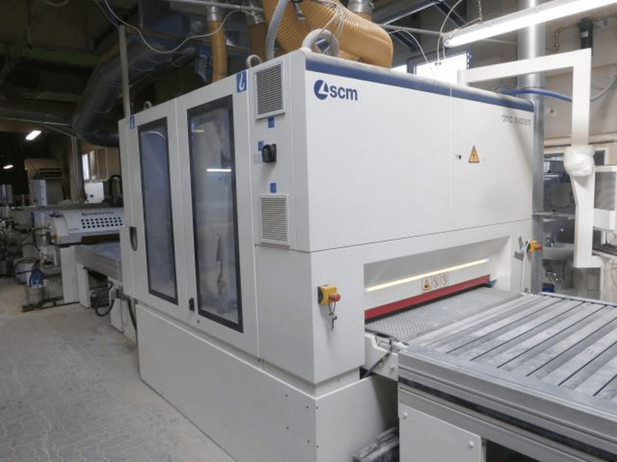 Testo Alt: Vista frontale di una macchina per la lavorazione del legno SUPERFICI Valiorta F1 B con porte trasparenti e pannello di controllo a vista.