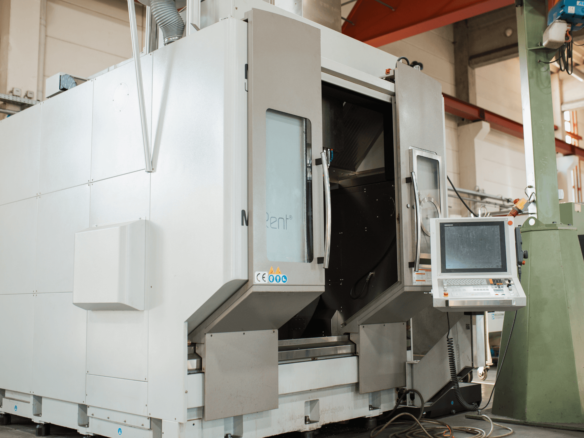 La fresatrice CNC N Rent®, vista frontale, presenta un pannello di controllo con schermo, porte aperte e ambiente industriale.