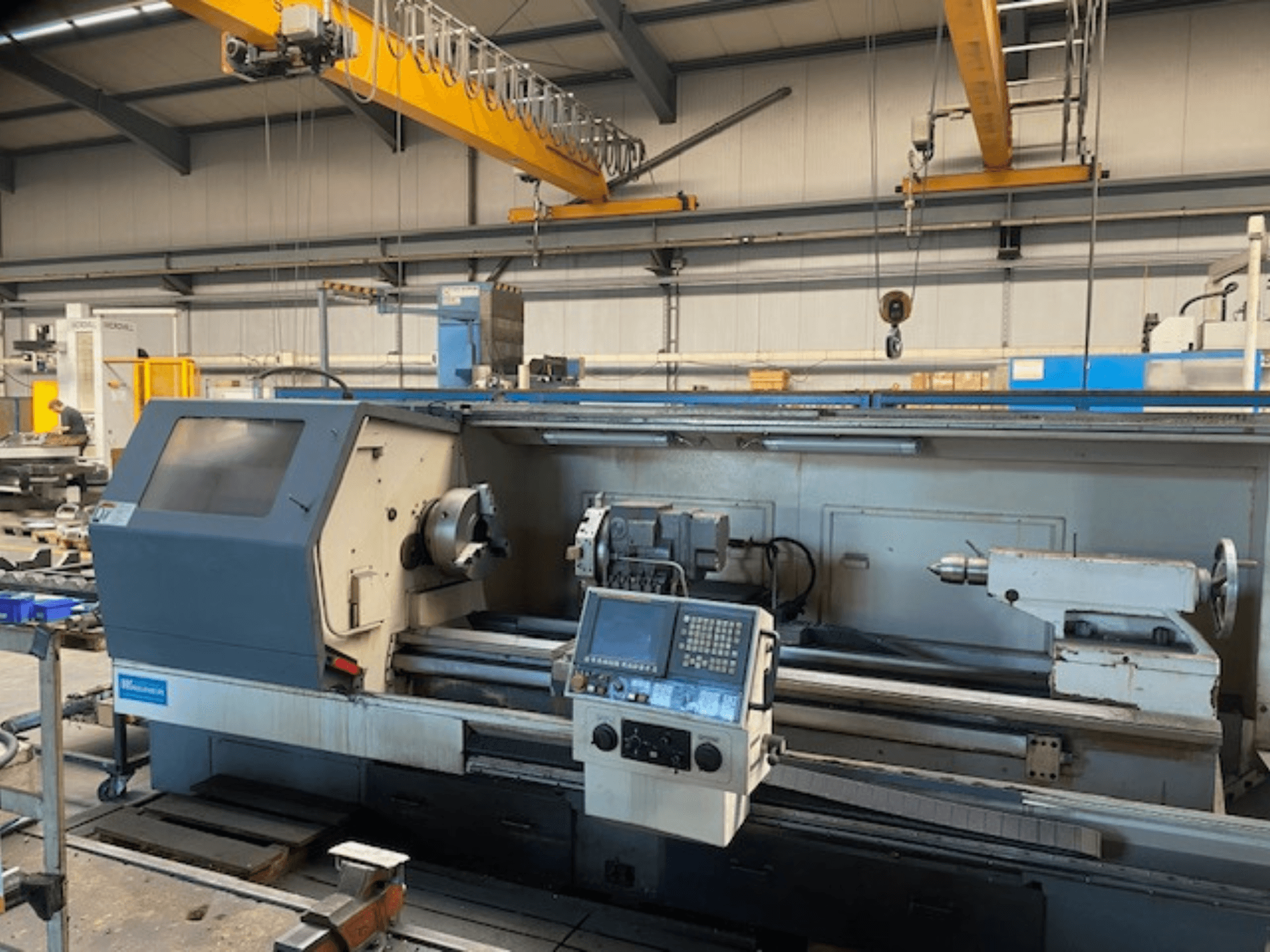 Tornio di precisione Wabeco, vista frontale con pannello di controllo, che mostra l'impostazione del mandrino e degli utensili in un ambiente di fabbrica.