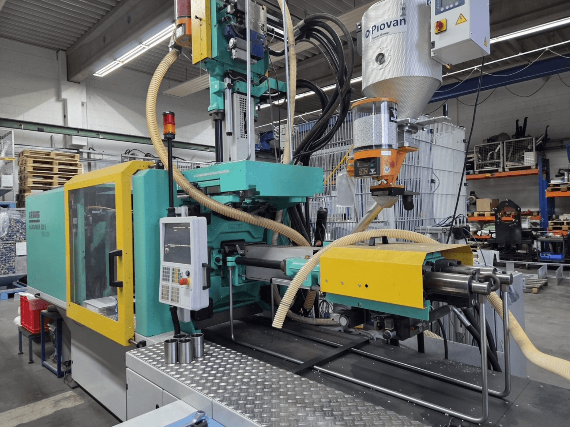 Pressa a iniezione idraulica Arburg Allrounder 520 S 1600-290, vista frontale, con pannello di controllo e alimentatore del materiale visibili.