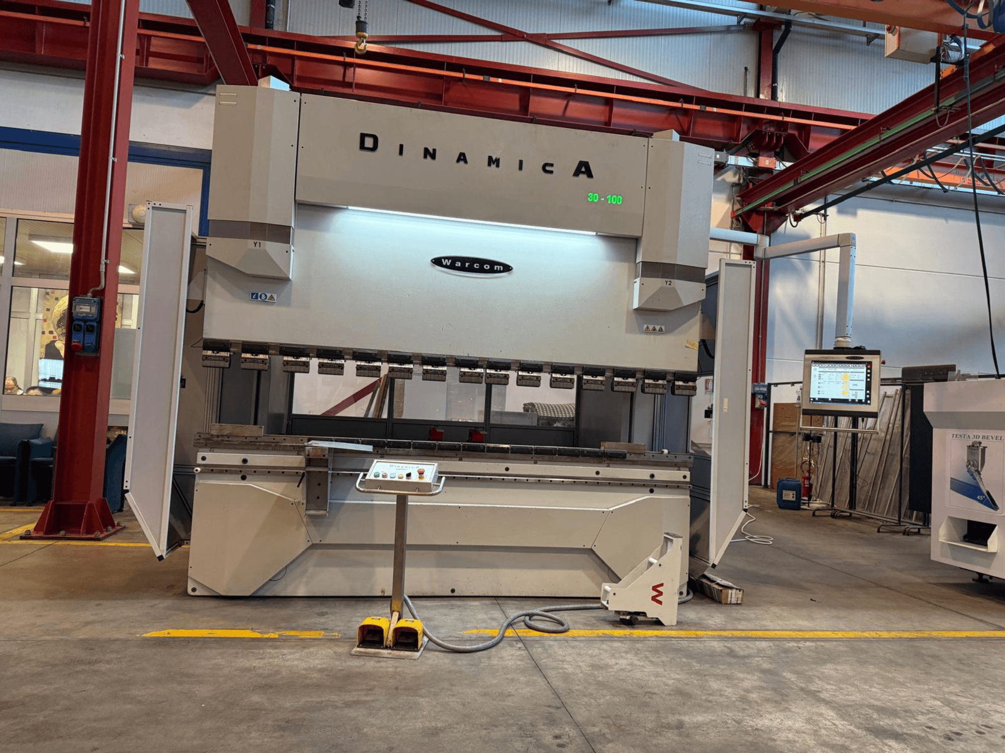 Pressa piegatrice idraulica Dinamica Warcom, vista frontale. Pannello di controllo e stazioni multiple per la piegatura di precisione.