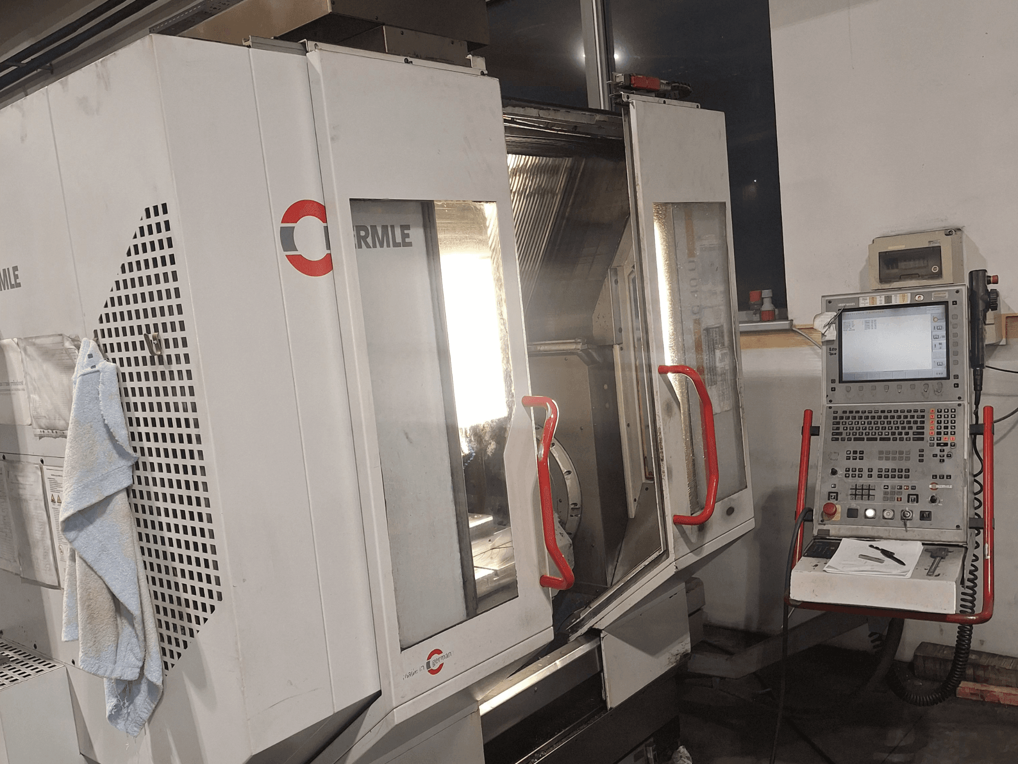 Macchina CNC del marchio Cormile, vista frontale con porte parzialmente aperte e pannello di controllo con schermo e pulsanti.