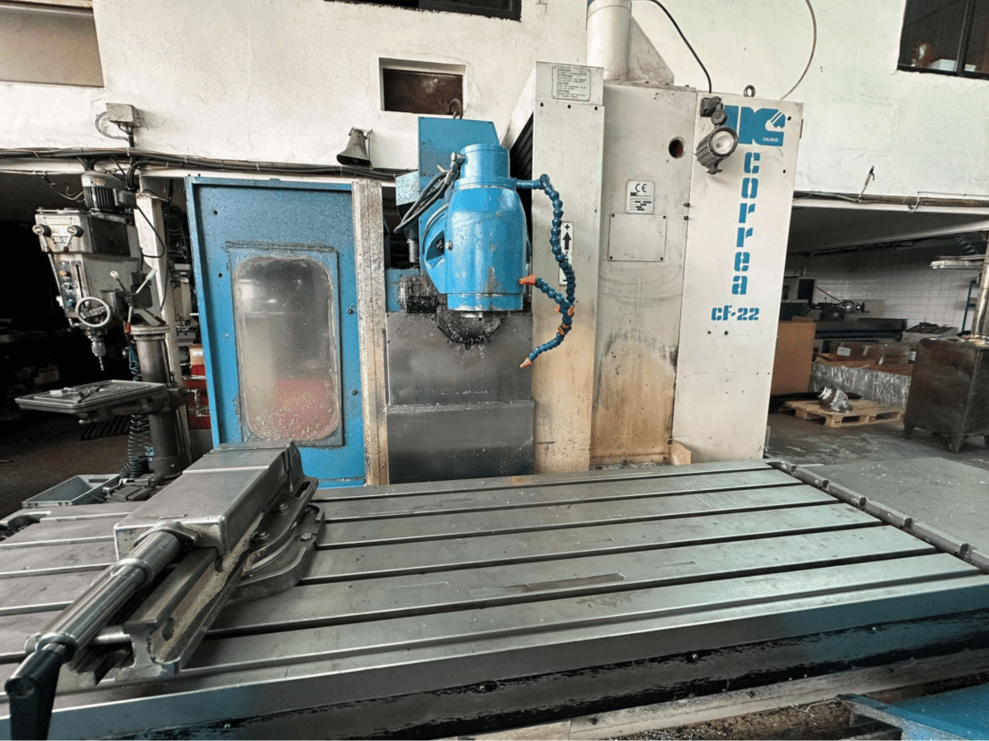 Fresatrice Correa CF-22, vista frontale; presenta un piano di lavoro in metallo e un pannello di controllo blu e bianco con manopole.