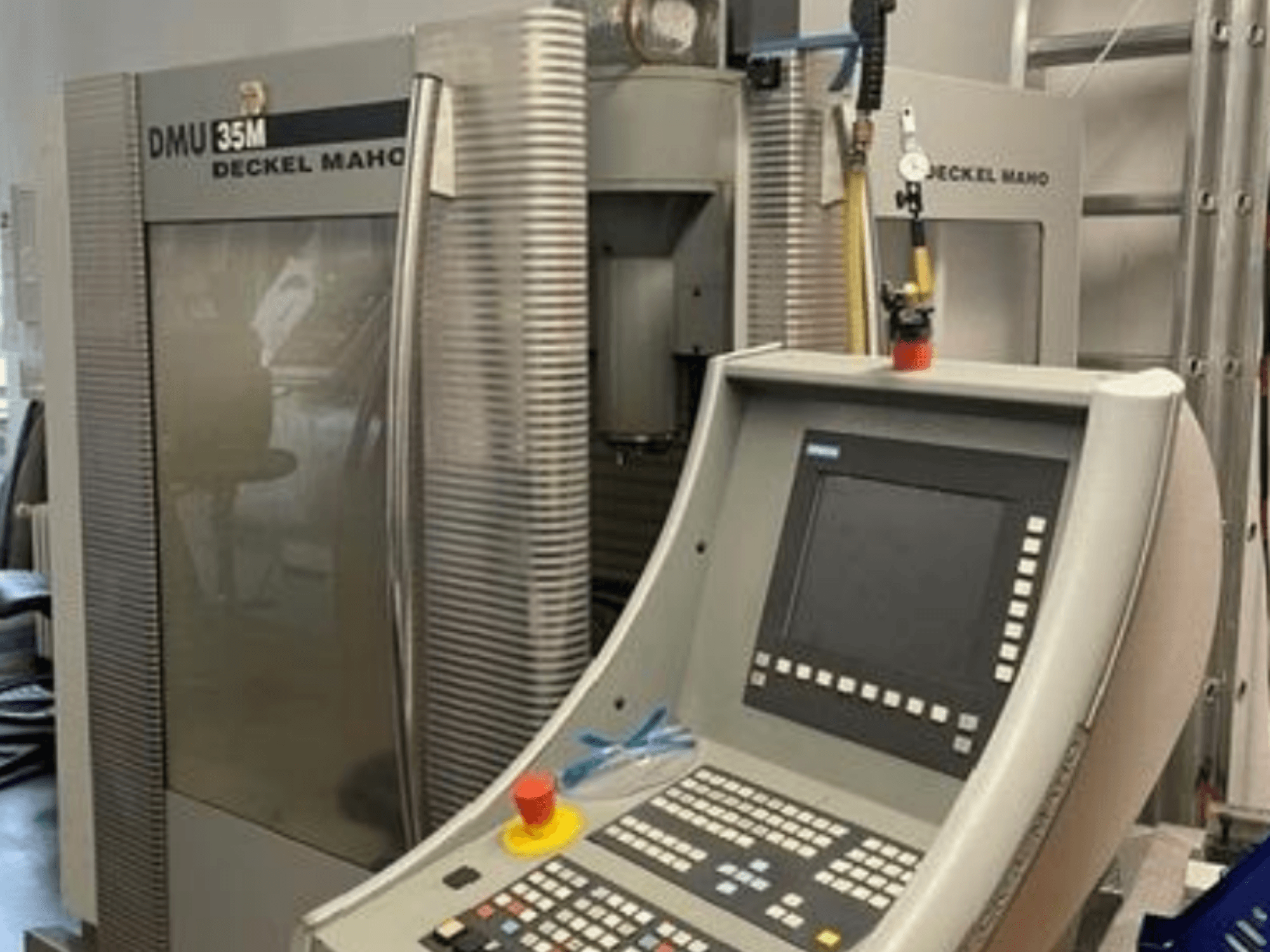 Vista frontale del centro di lavorazione universale DECKEL MAHO DMU 35M, con pannello di comando e dettagli della macchina.