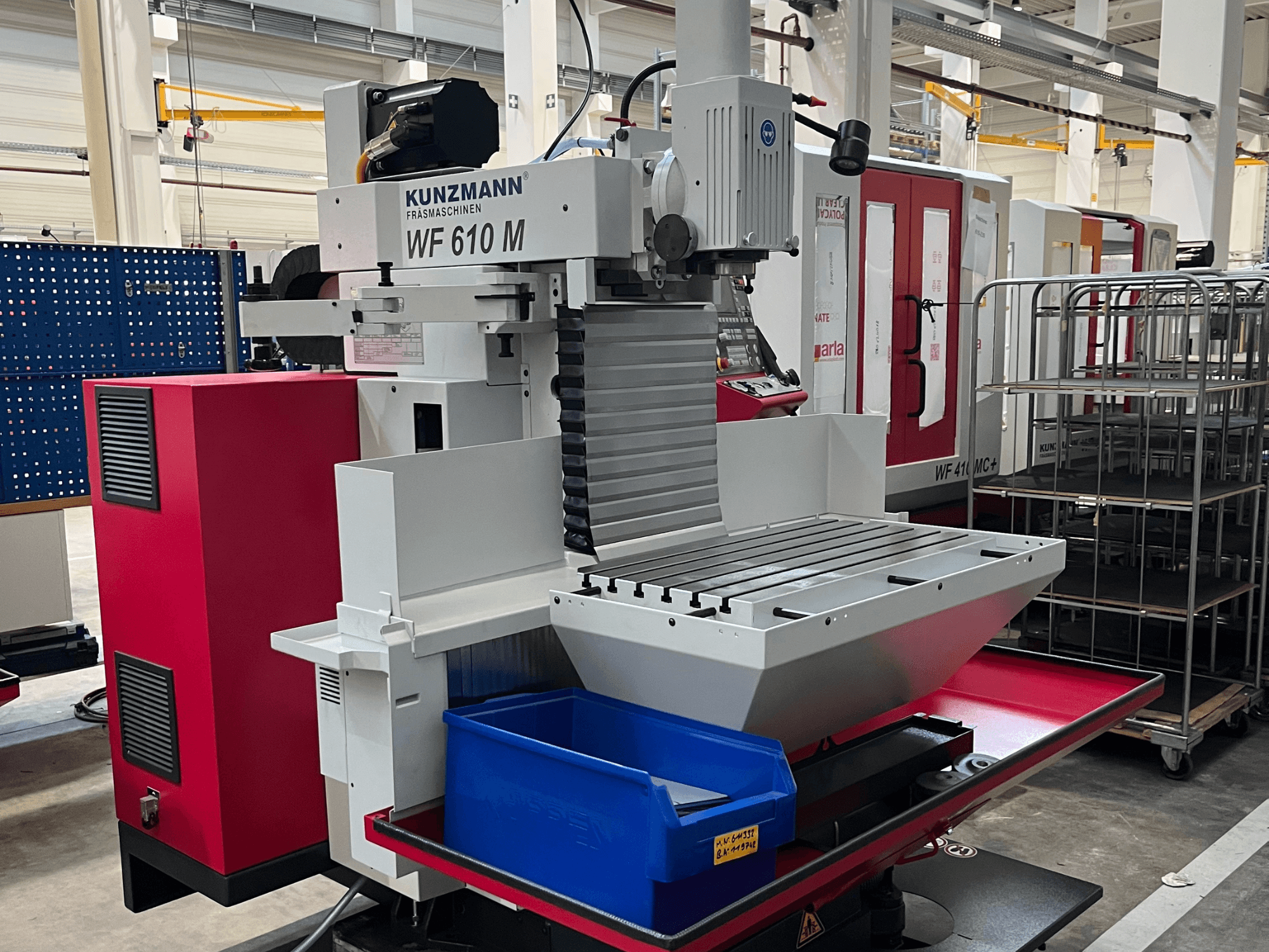 Centro di lavorazione universale KUNZMANN WF 610 M, vista frontale, dotato di portautensili, tavola orizzontale e contenitore di stoccaggio blu.