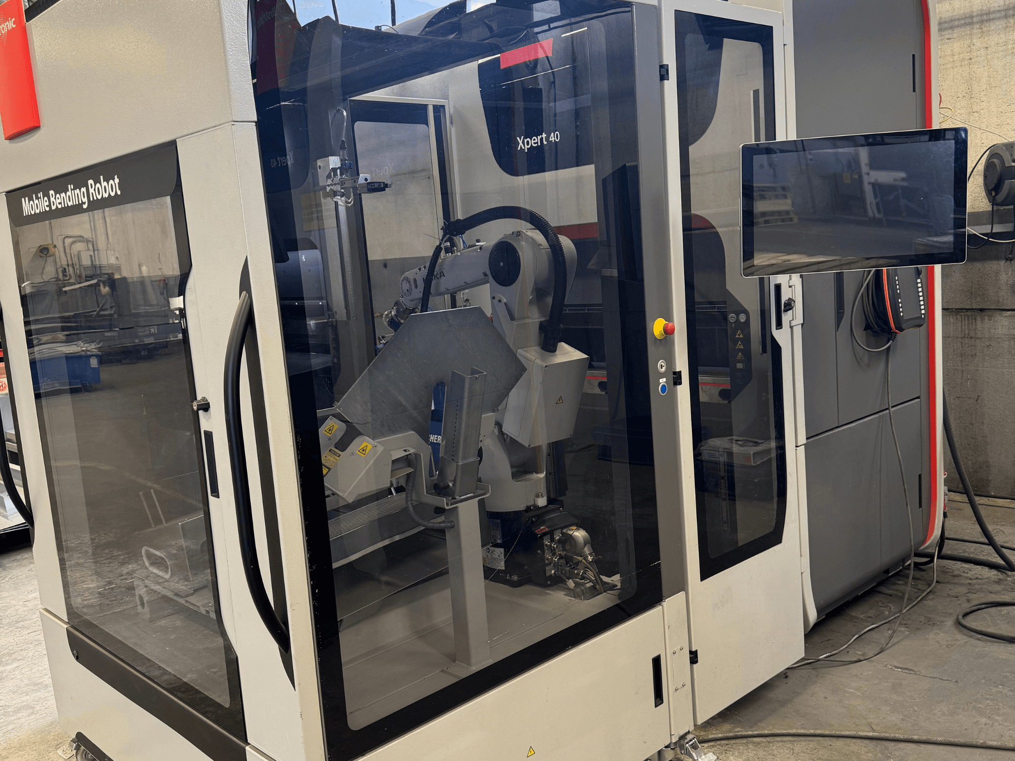 Pressa piegatrice Bystronic Xpert 40/1030 con robot di piegatura mobile, vista frontale del pannello di controllo e dei componenti robotici.