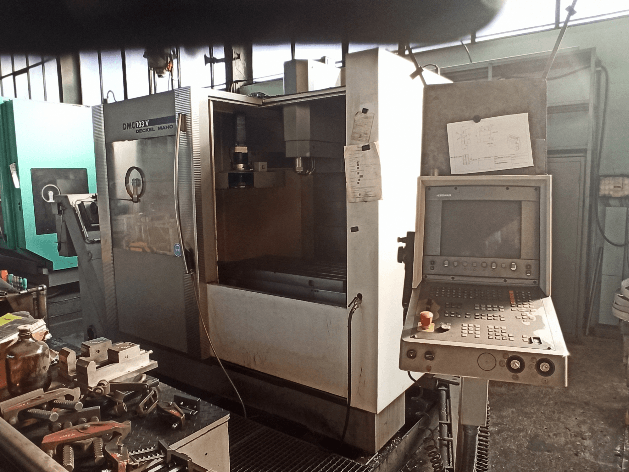 Centro di lavorazione verticale DECKEL MAHO DMC 103 V in un'officina, vista frontale che mostra il pannello di comando e l'area di lavorazione.