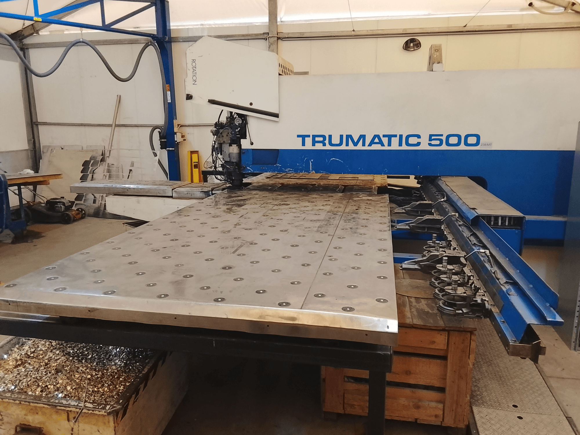 Macchina CNC Trumatic 500, vista dall'alto, con un grande tavolo da taglio in metallo con utensili montati e trucioli sottostanti.