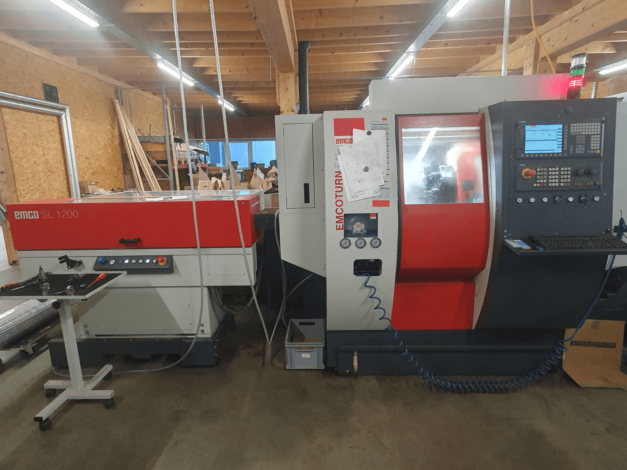 Tornio CNC EMCO SL 1200 e EMCOturn; vista frontale che mostra comandi, display e indicatori operativi in un'officina.