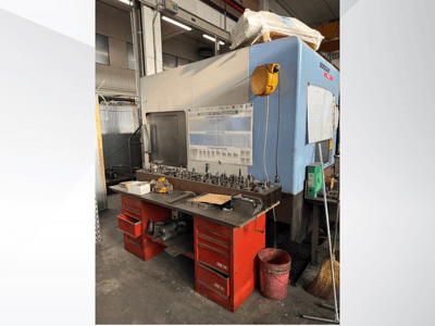 Centro di lavoro Doosan con banco di lavoro rosso e magazzino, che espone utensili e attrezzature, visto dal davanti.