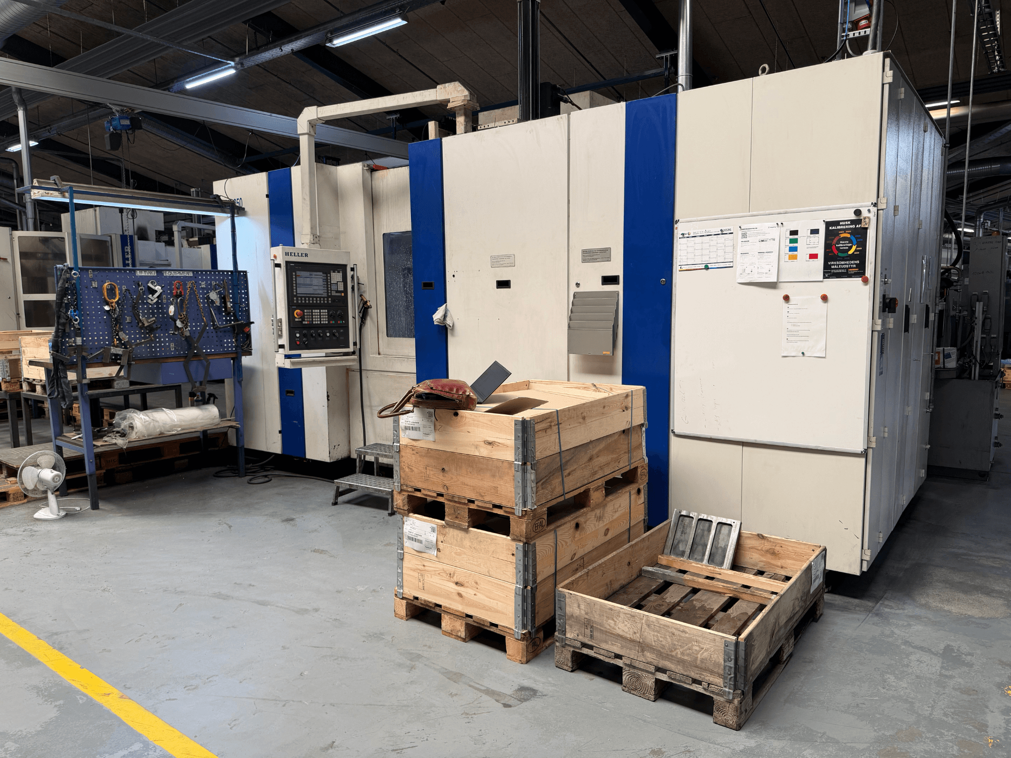 CENTRO MACCHINE ORIZZONTALE HELLER MCH 250 in officina, vista laterale con pallet di legno e portautensili visibili.