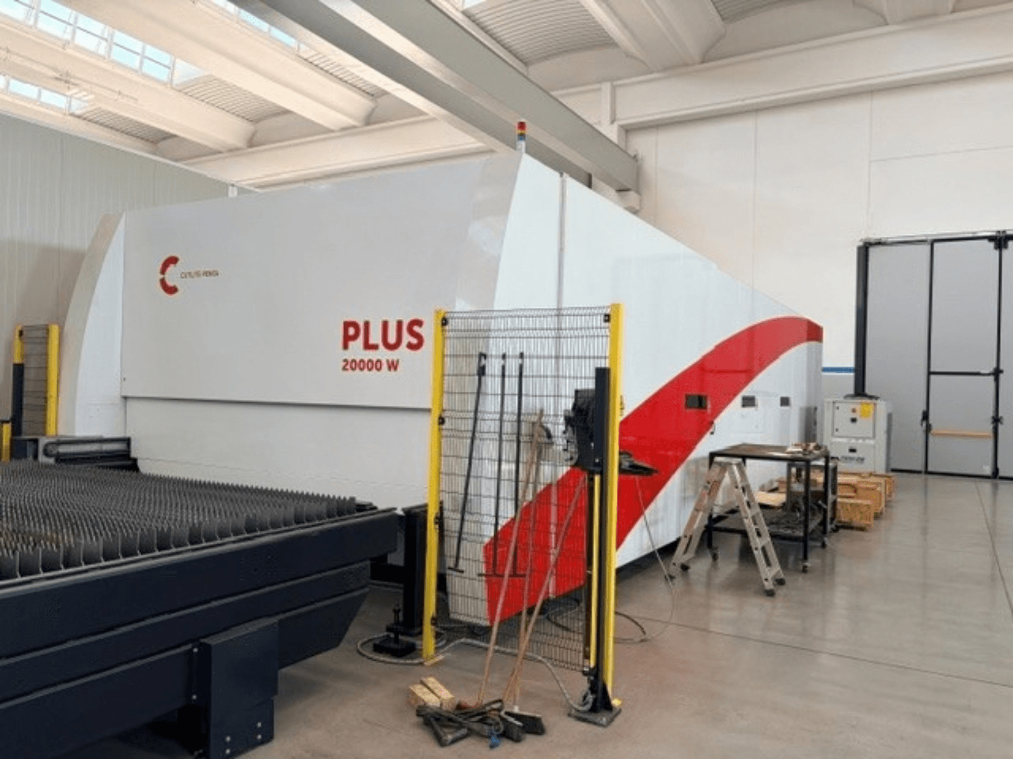 Macchina per il taglio laser a fibra CUTLITE PENTA PLUS LM 9030, vista laterale, che mostra la potenza di 20.000 W, con recinzione di protezione e area di lavoro.