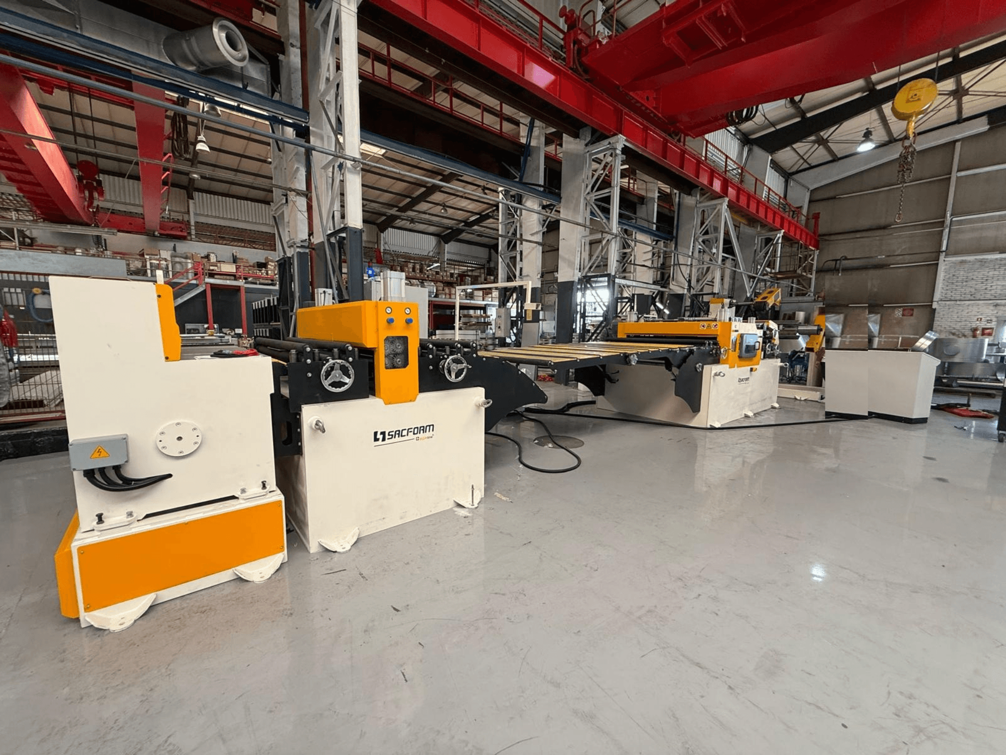 Vista frontale della macchina per la lavorazione della lamiera SACFORM CRL1503-6, caratterizzata da un design giallo e bianco, ruote e comandi operativi.