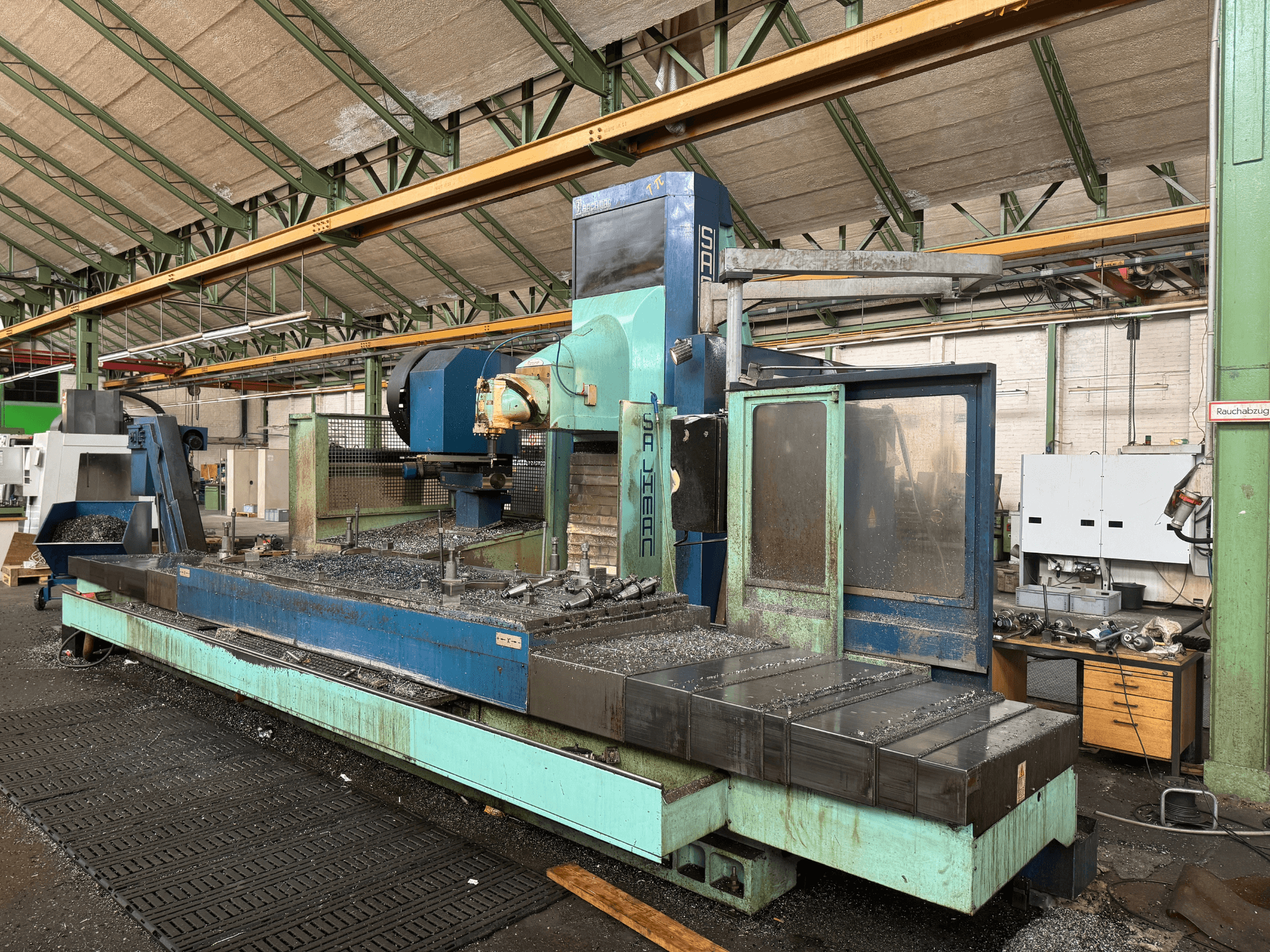 Fresatrice Salvador in fabbrica, vista frontale, con una combinazione di colori blu e verde, che mostra i trucioli di metallo sul basamento.