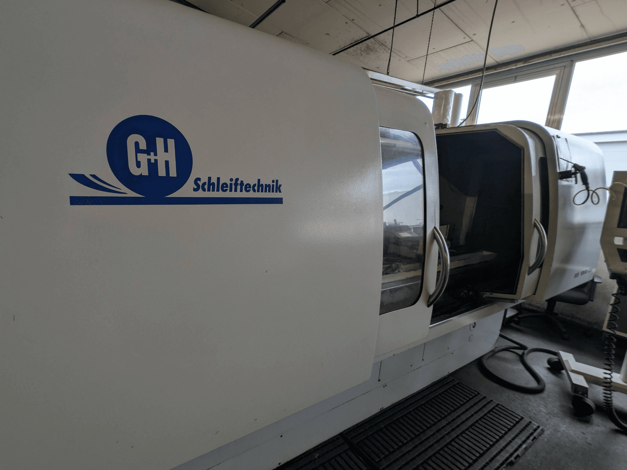 Rettificatrice cilindrica GEIBEL & HOTZ RS 1000 CU, vista laterale con pannello di controllo e porta di accesso aperta.