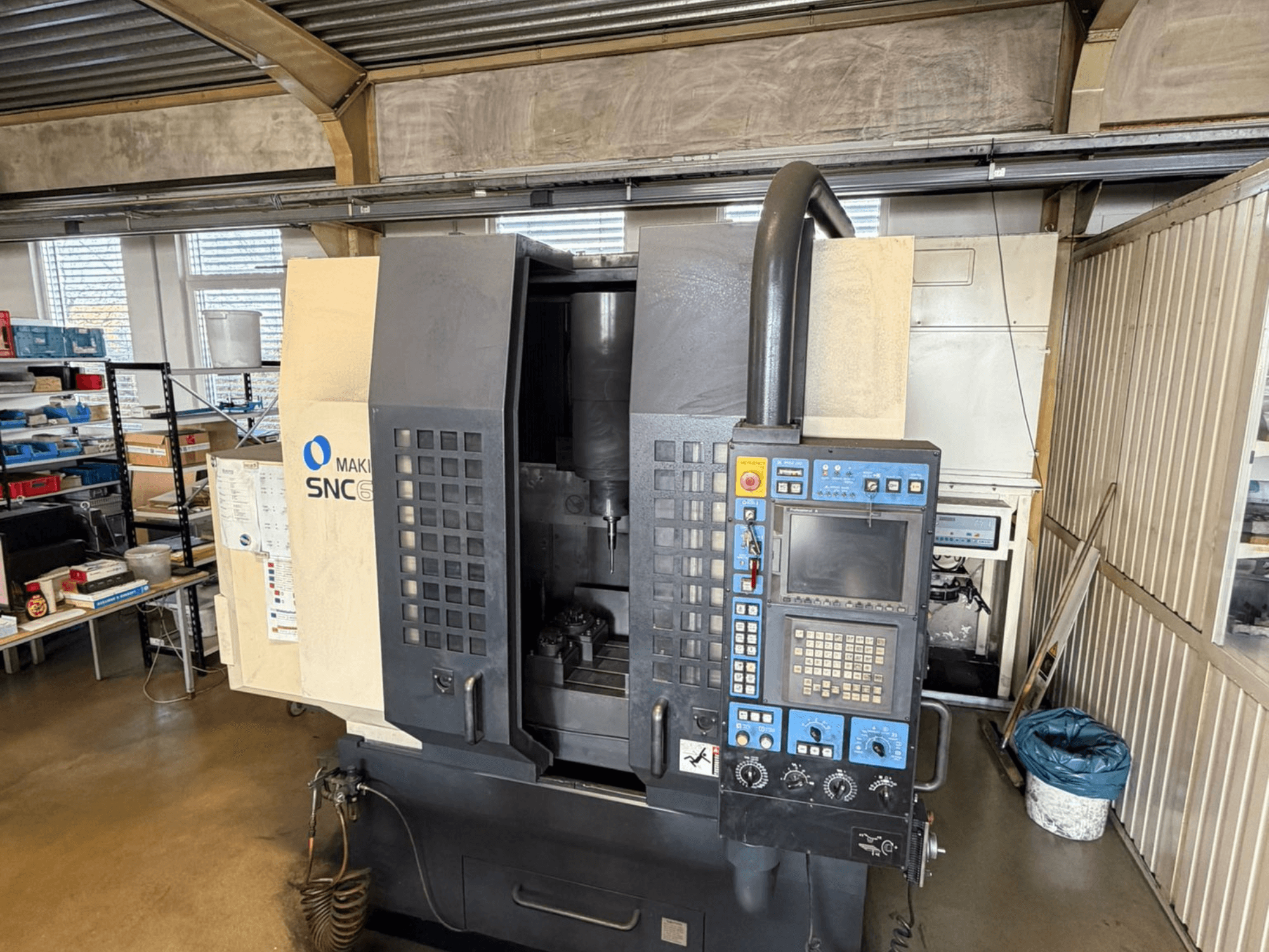 Centro di lavoro verticale Makino SNC 64-A15 in vista frontale, con pannello di controllo, area di lavorazione e spazio di lavoro industriale.