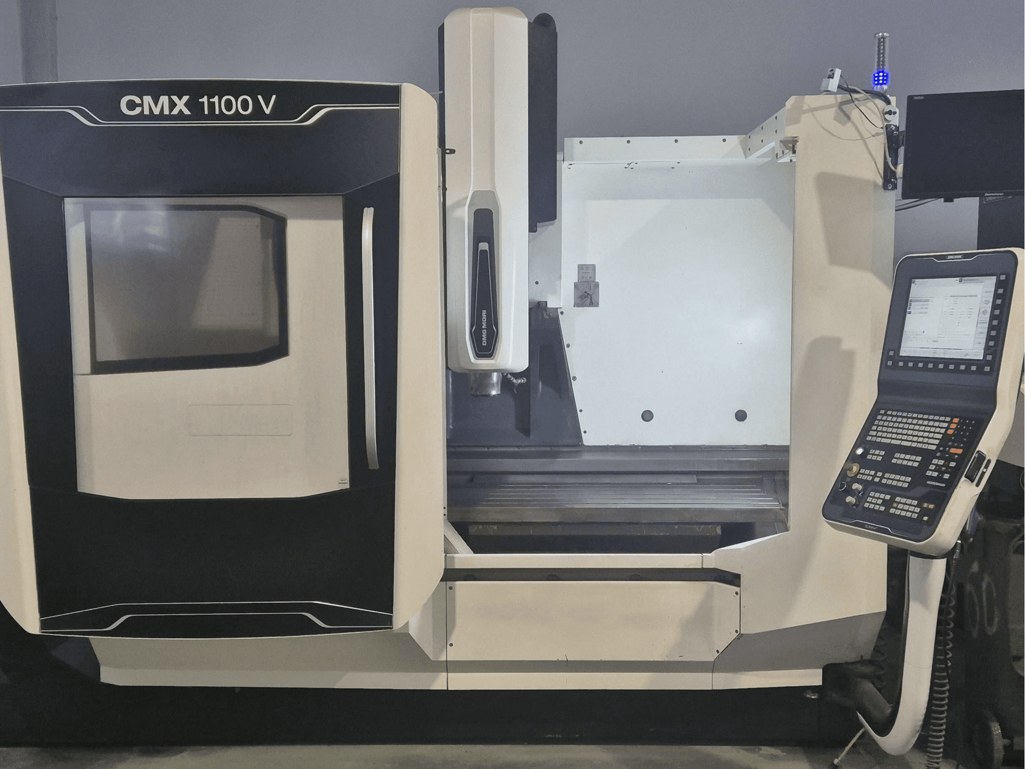 Centro di lavorazione verticale DMG MORI CMX 1100 V, vista frontale che mostra il pannello di controllo e il basamento della macchina.