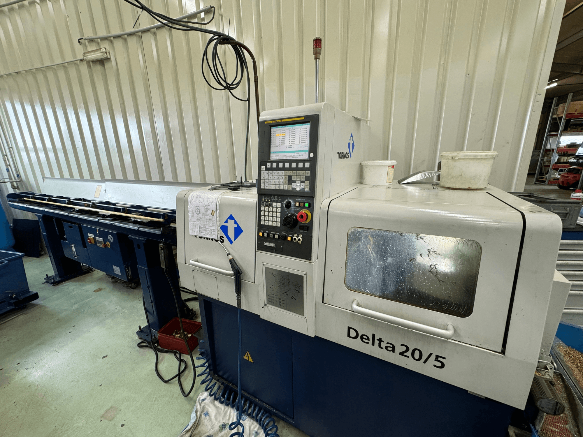 Macchina CNC Torino Delta 20/5, vista frontale, con pannello di controllo e area di lavoro. Vetro acidato e cablaggio a vista.
