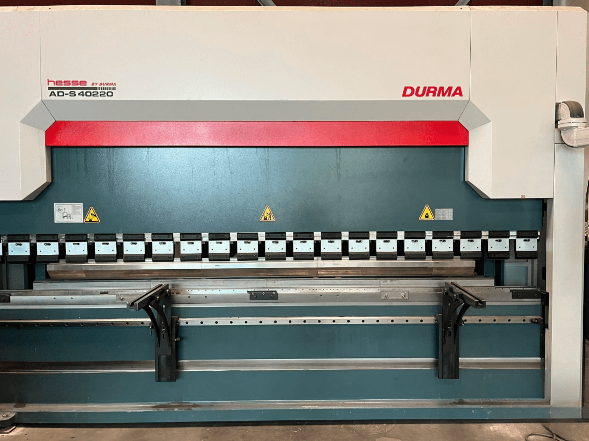 Piegatrice Durma AD-S 40220 vista frontalmente, dotata di diversi utensili di piegatura ed etichette di sicurezza.