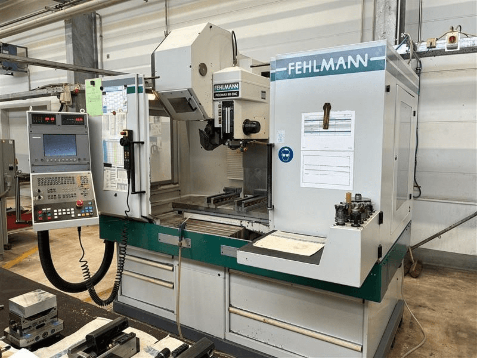 Centro di lavorazione verticale FEHLMANN PICOMAX 80 CNC-W 2/3 visto frontalmente, con pannello di controllo e area di lavorazione.