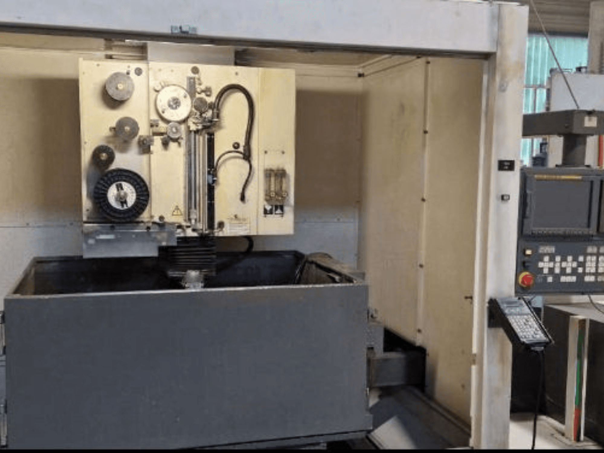 Macchina per elettroerosione a filo FANUC ROBOCUT α-1iA, vista frontale con pannello di controllo, vasca di lavoro e componenti della macchina.