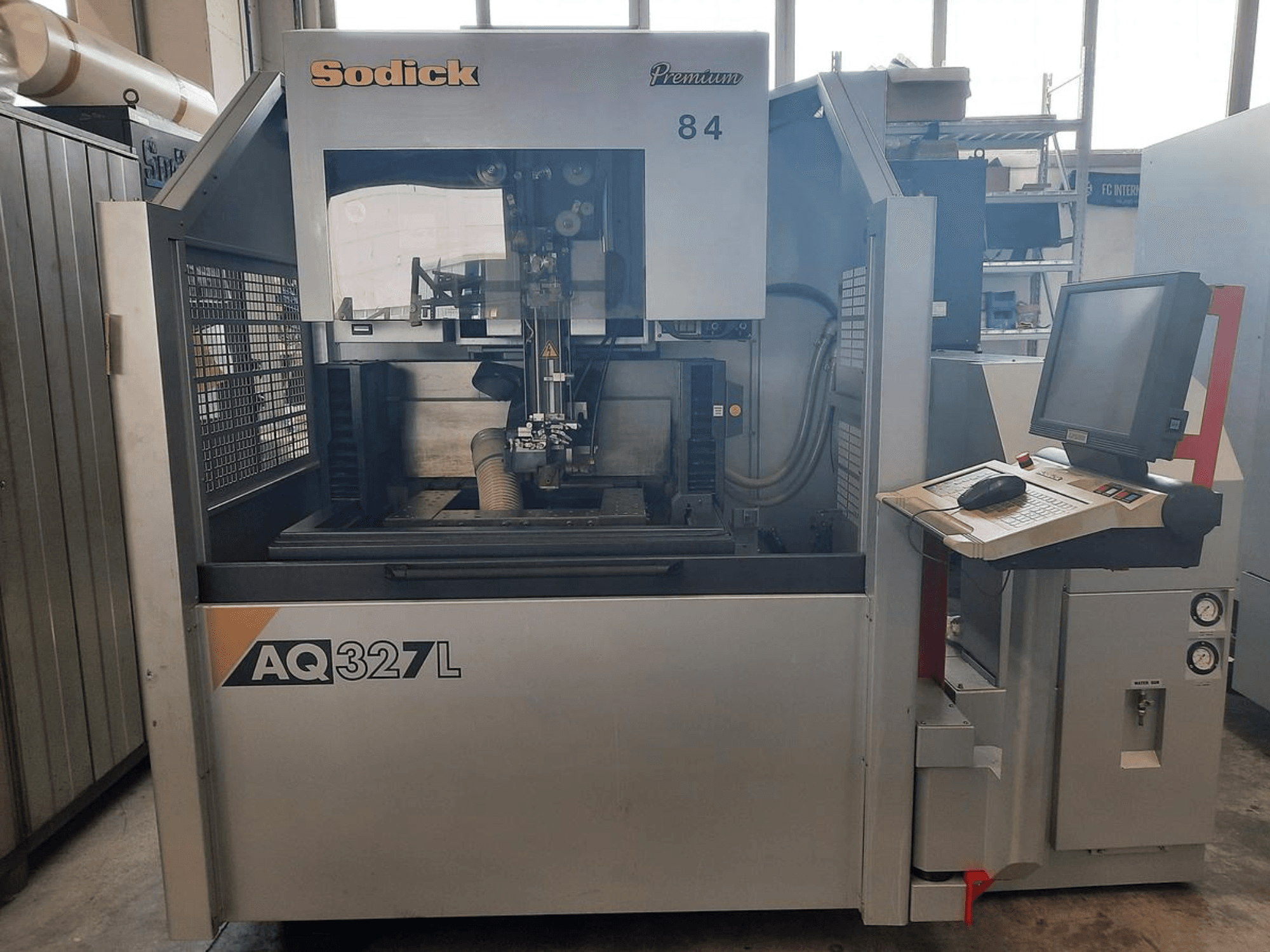 Macchina Sodick AQ327L in vista frontale, con pannello di controllo, interfaccia utente e area di taglio visibile all'interno.
