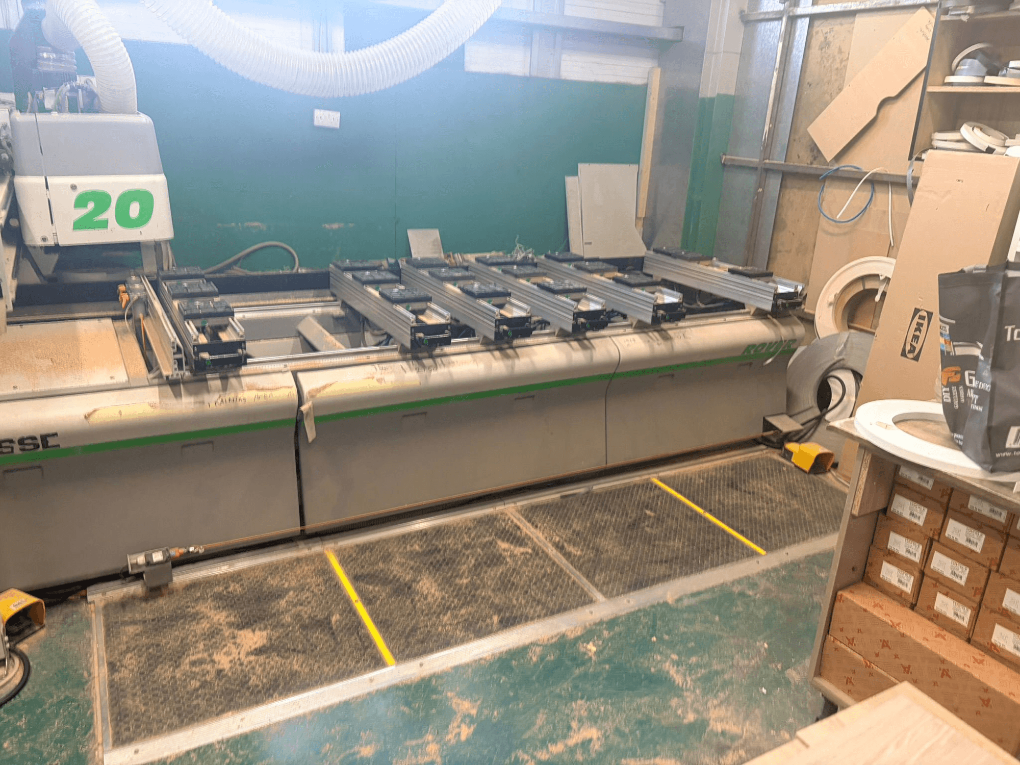 Centro di lavorazione del legno a CNC BIESSE ROVER 20, vista frontale, con sistema di guide, comandi e segatura visibile sulla superficie.