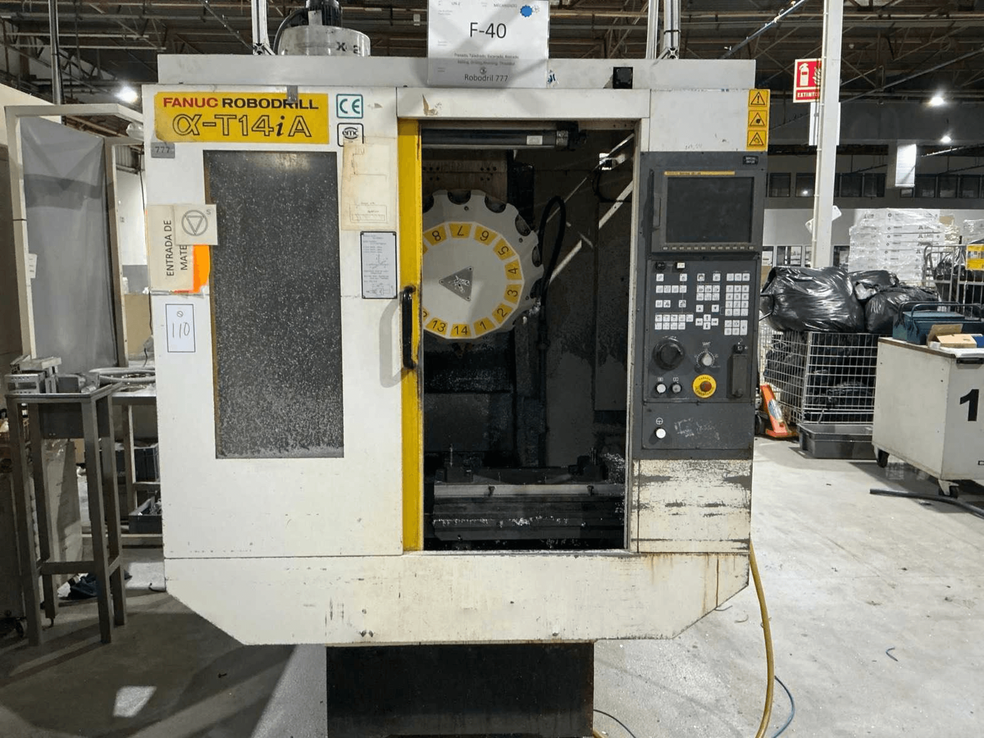 Centro di lavoro verticale FANUC ROBODRILL α-T14iB, vista frontale con pannello di controllo e carosello utensili.