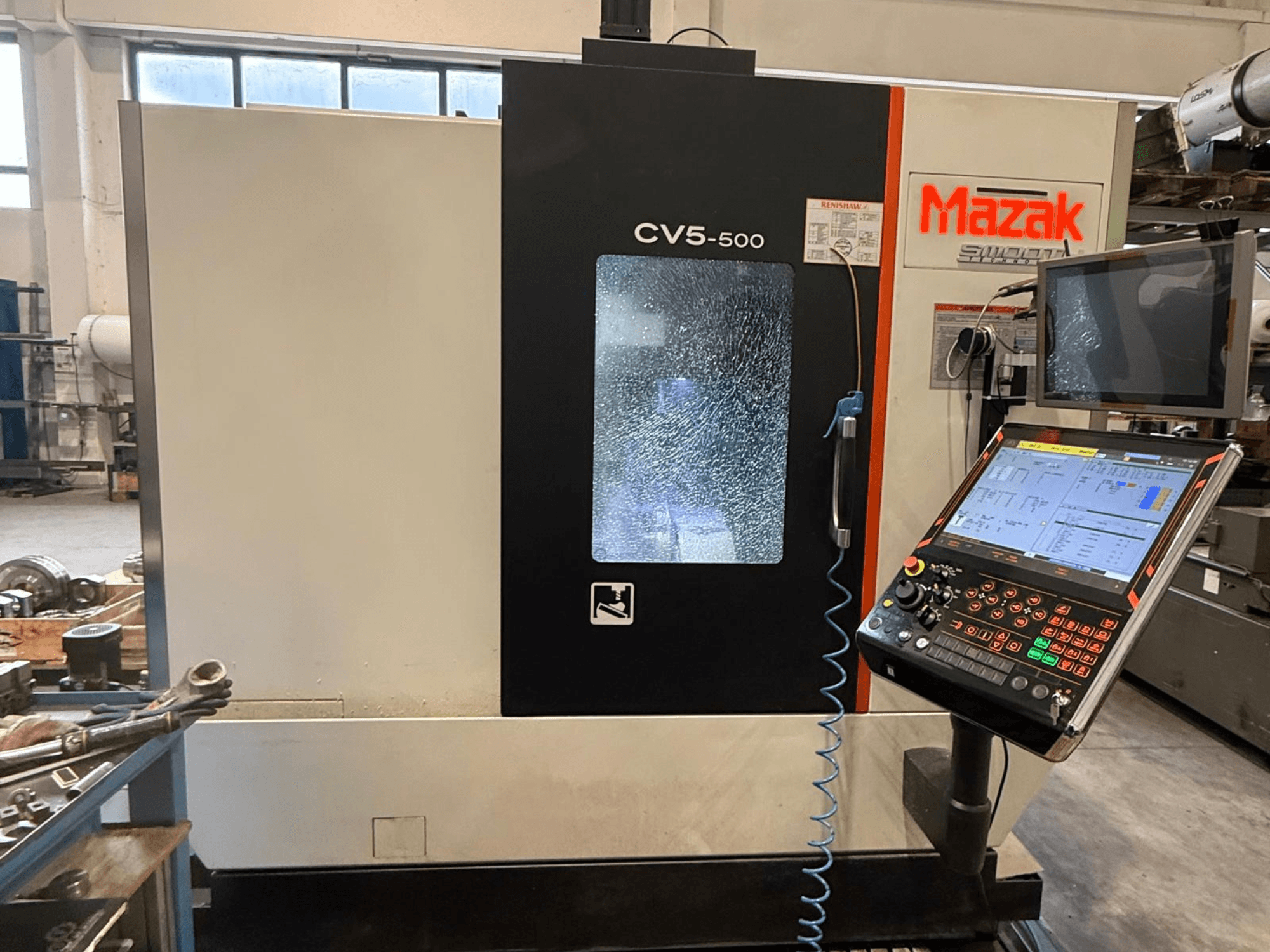 Centro di lavoro verticale Mazak CV5-500, vista frontale con pannello di controllo e display, che mostra le impostazioni operative e l'interfaccia.