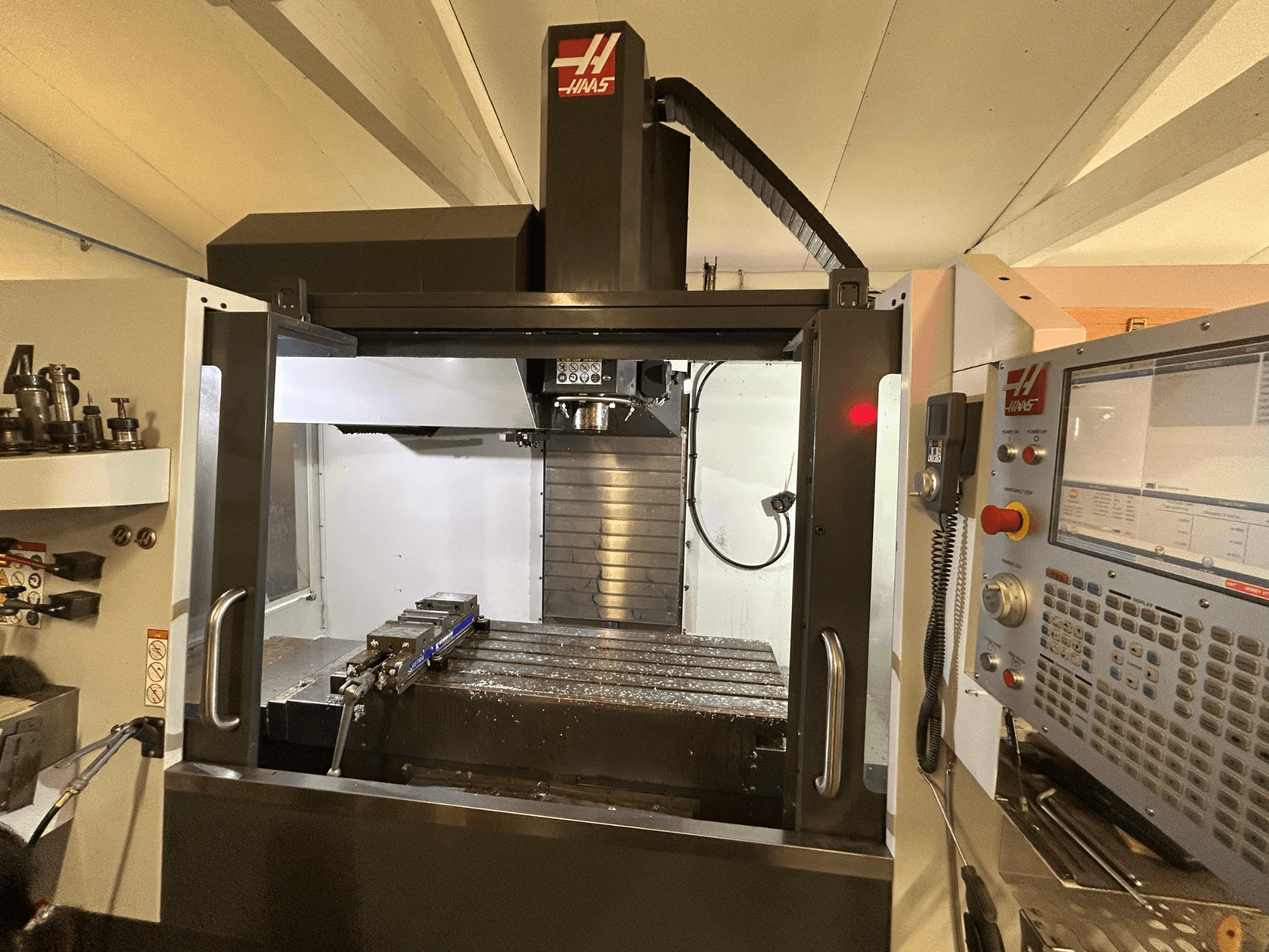 Centro di lavoro verticale HAAS VF-4SS, vista frontale, con pannello di controllo, portautensili e area di lavoro con trucioli metallici.