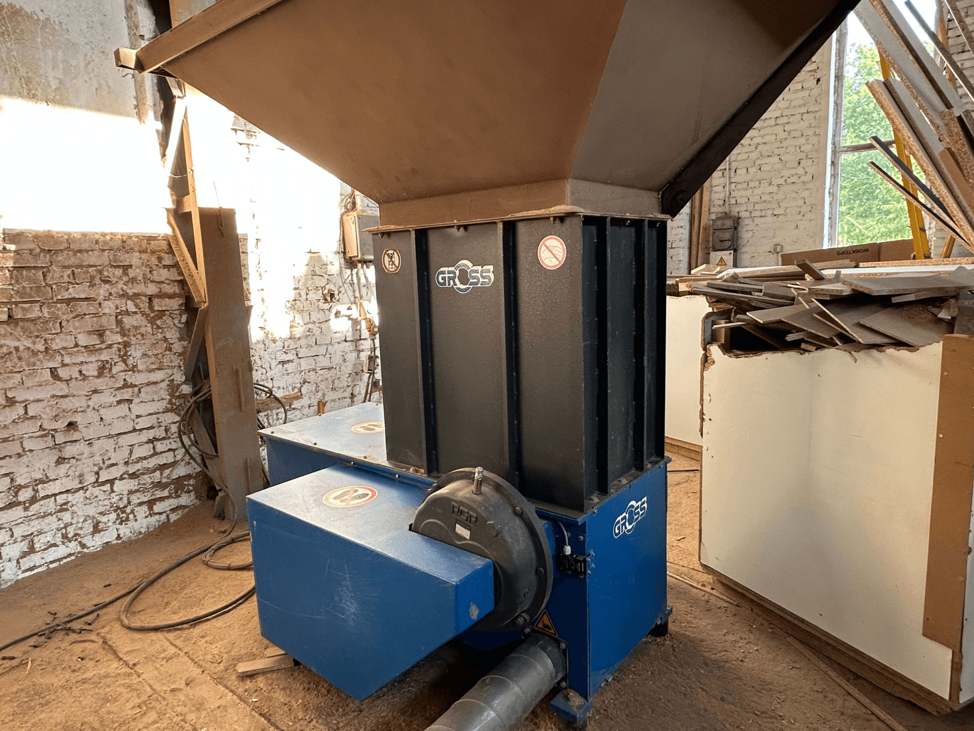 Macchina per la lavorazione del legno GROSS GAZ62 in un'officina, con tramoggia verticale e doppia base blu, vista di lato.